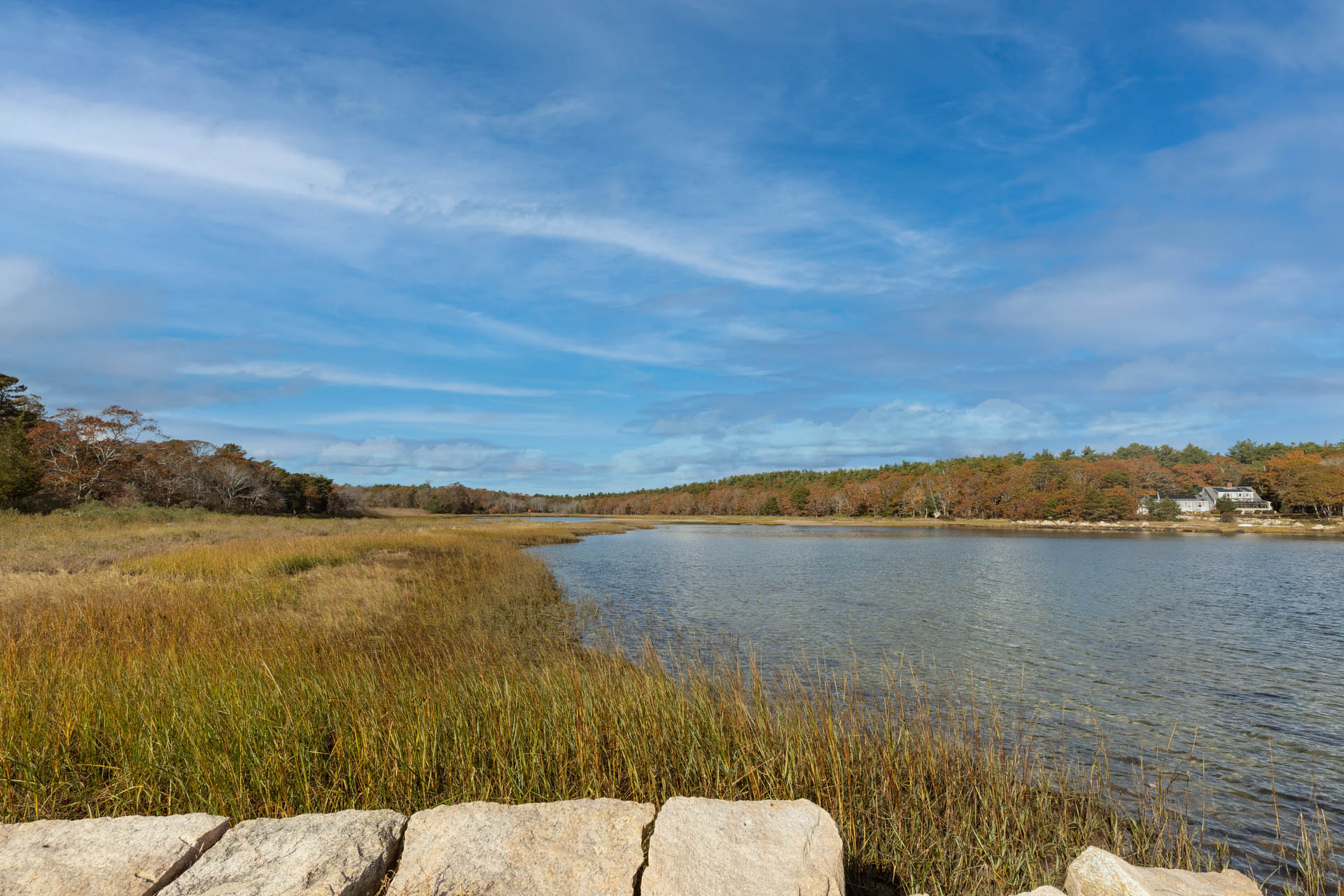 Square rocks on the bottom left part of the picture, looking out onto a tidal marsh.