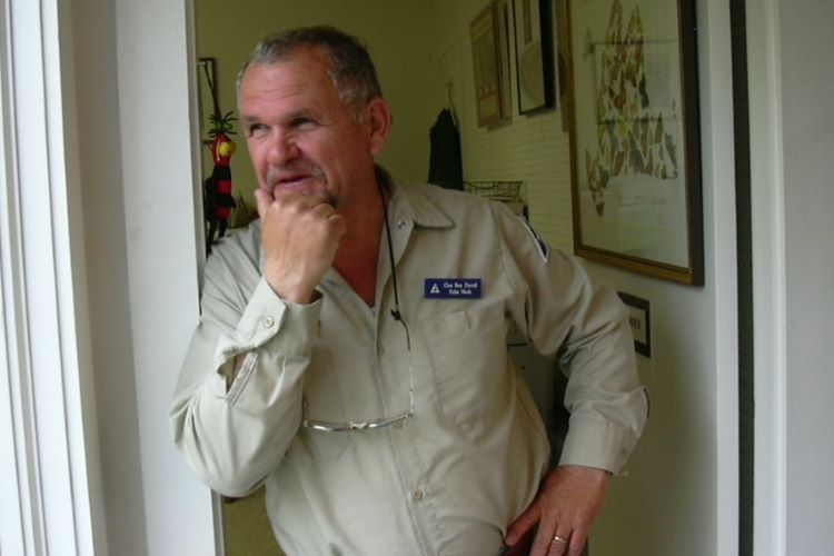 Man standing near window with hand on chin