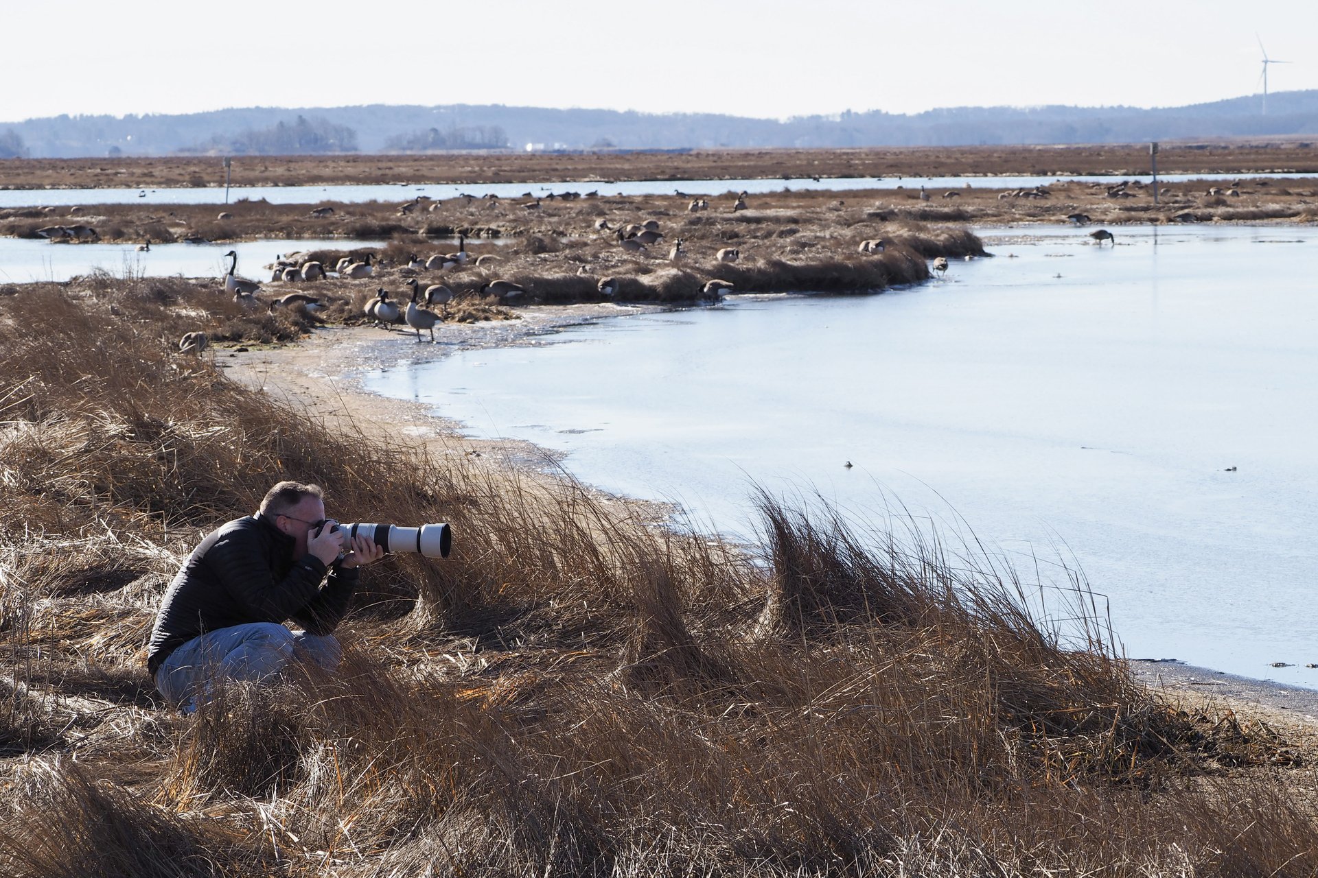 Man taking a photo at Plum Island in winter