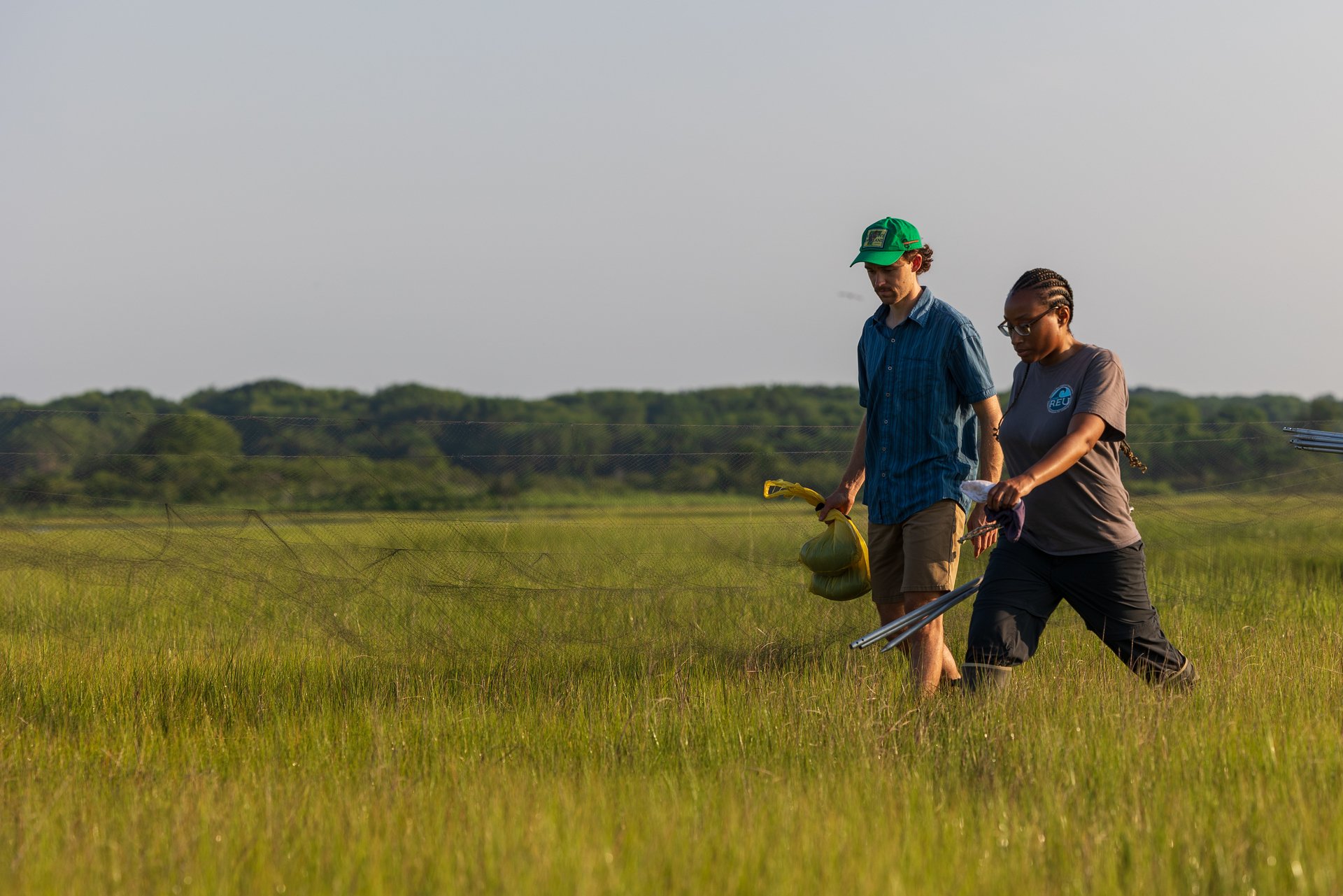 two people walking in marsh