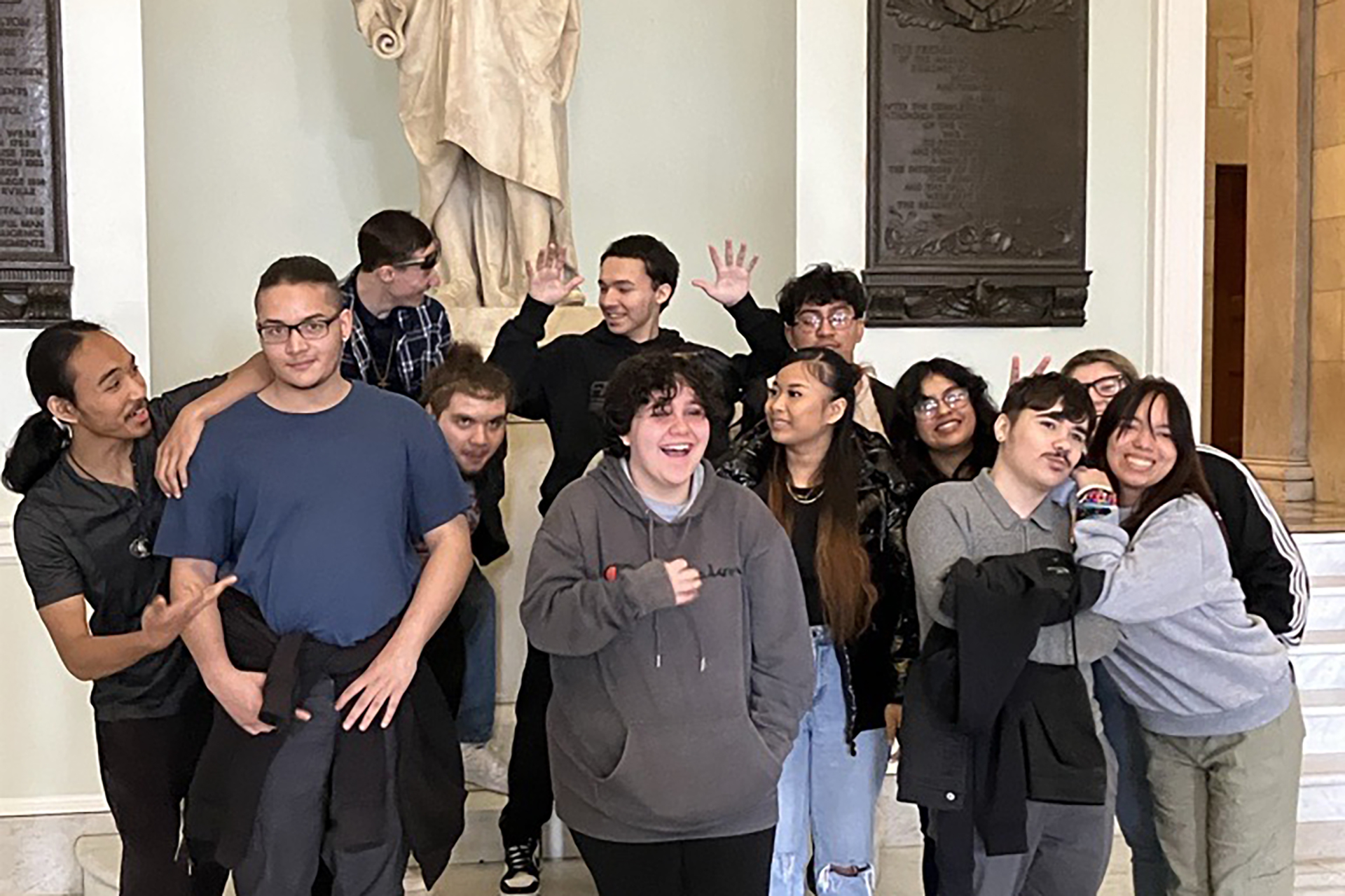 YCLP students posing for a group photo in front of a statue