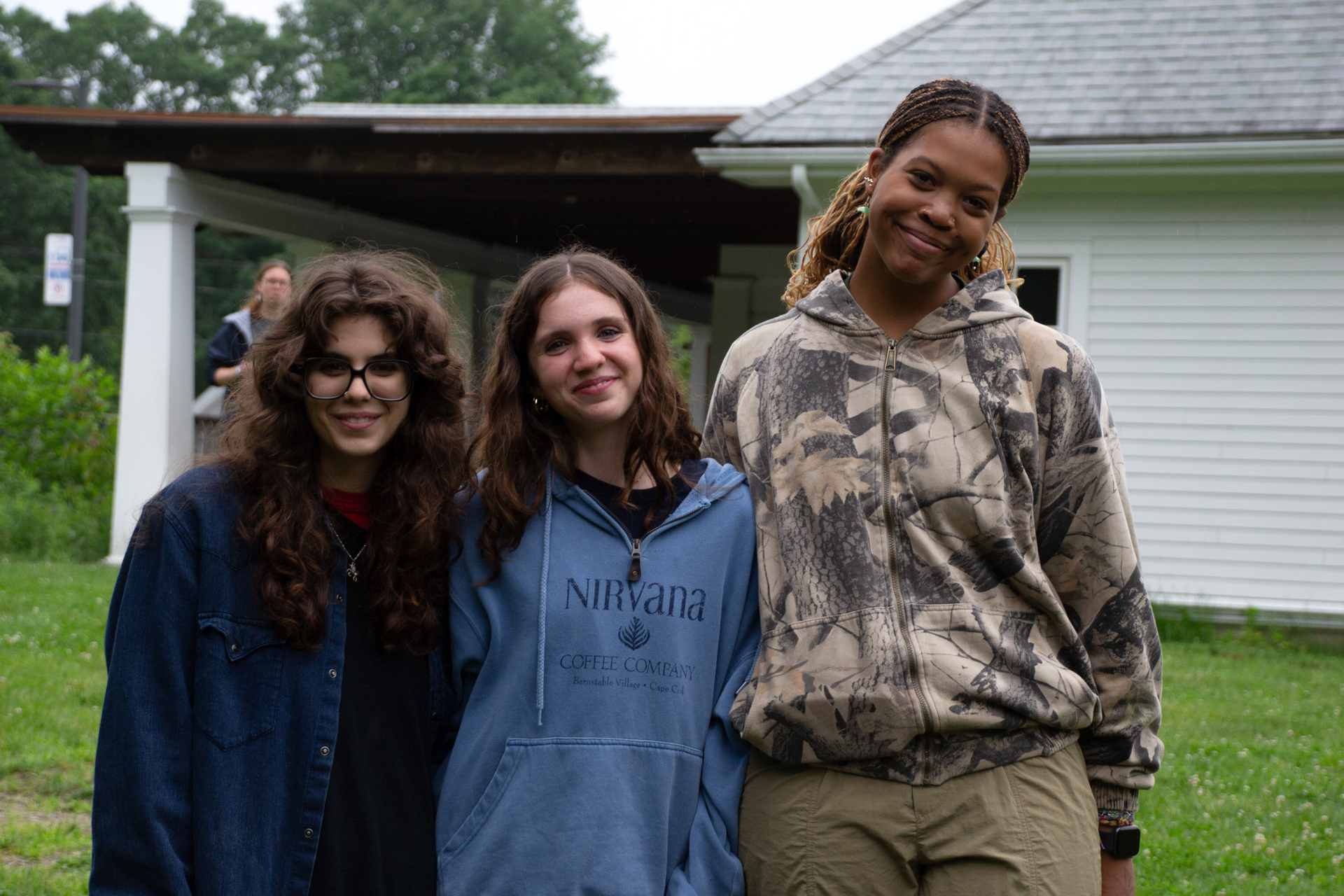 Three female counselors stand smiling together.