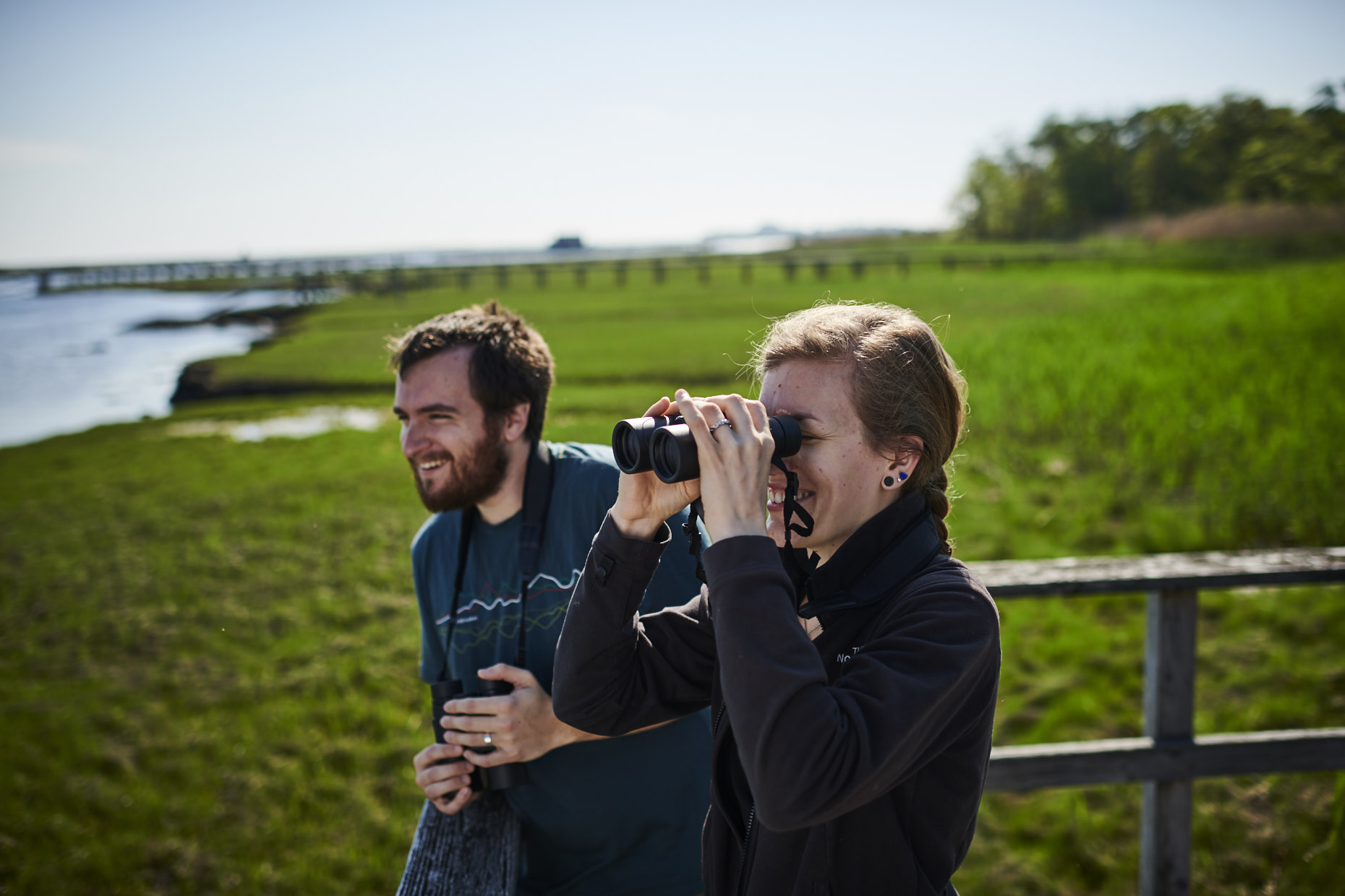 two adults birding on boardwalk