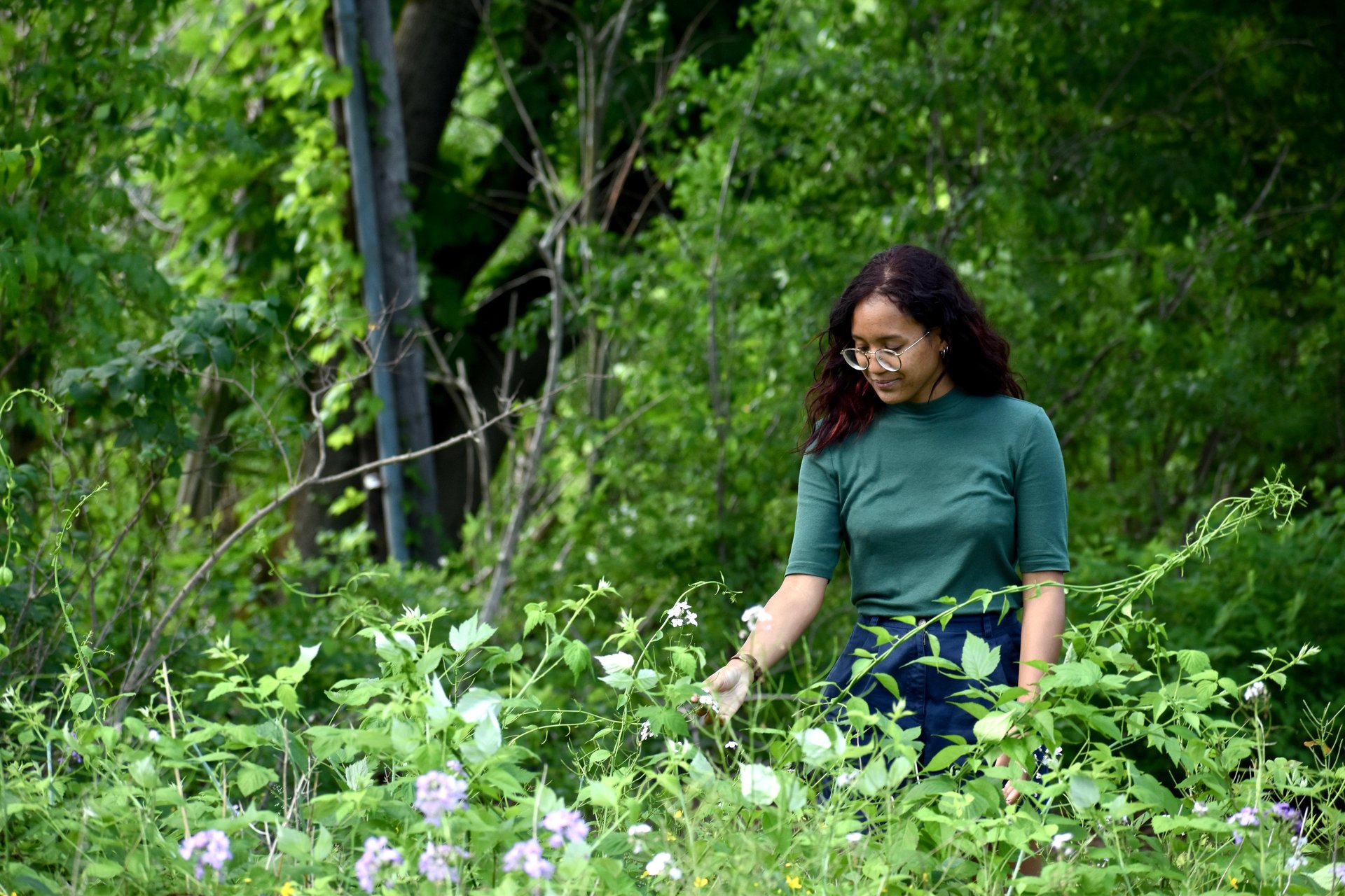 A young woman looking at a flower