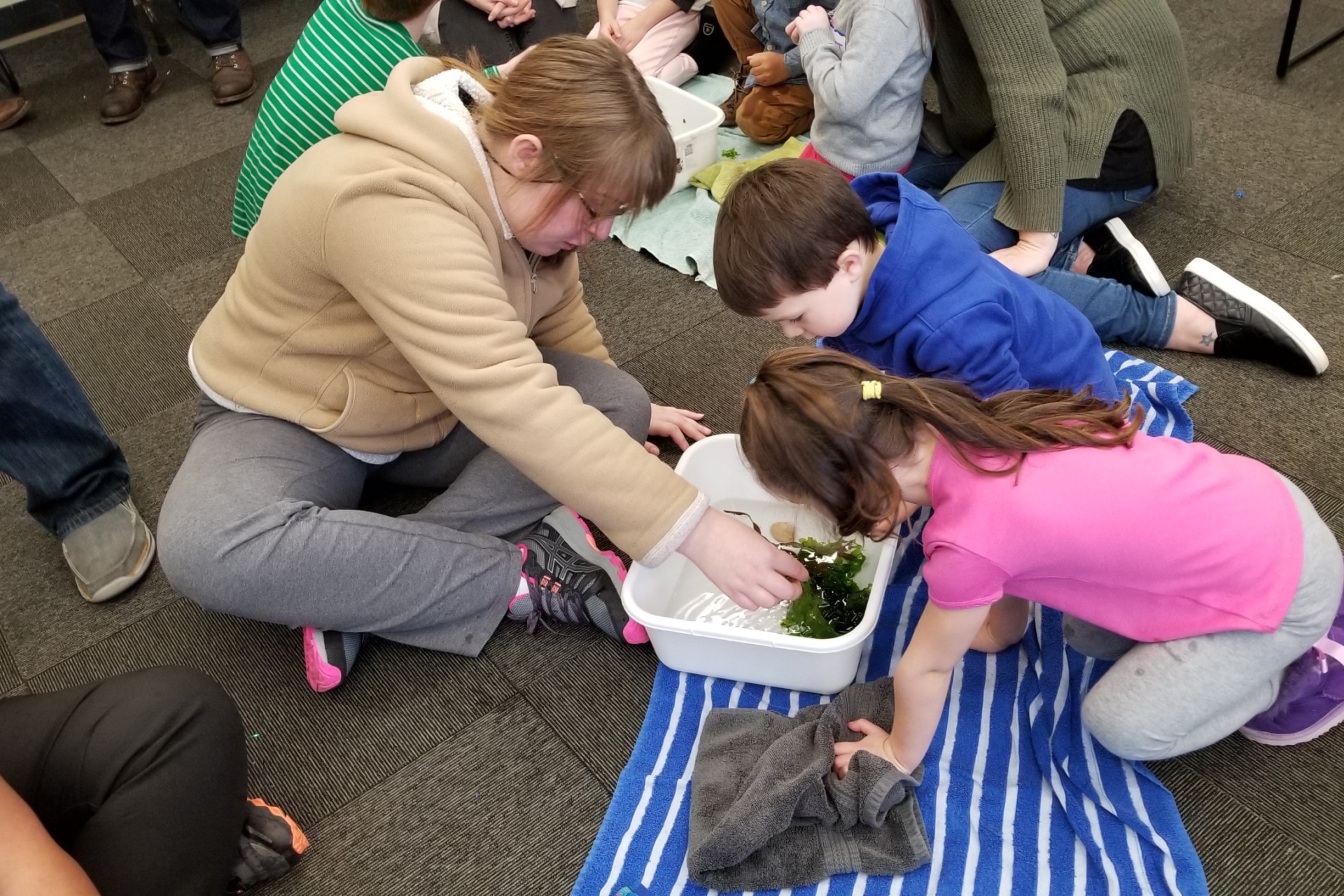 Katie looking at bin with children