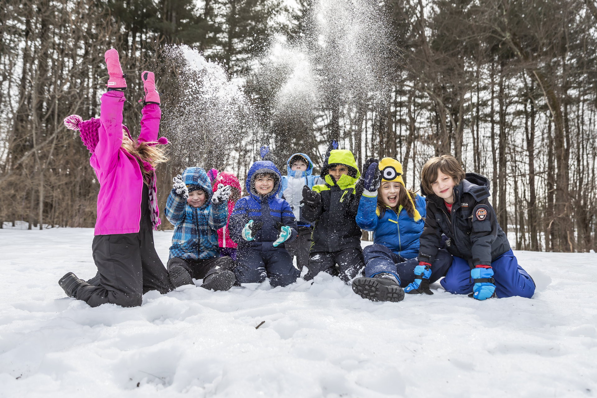 Young children throwing snow into the air