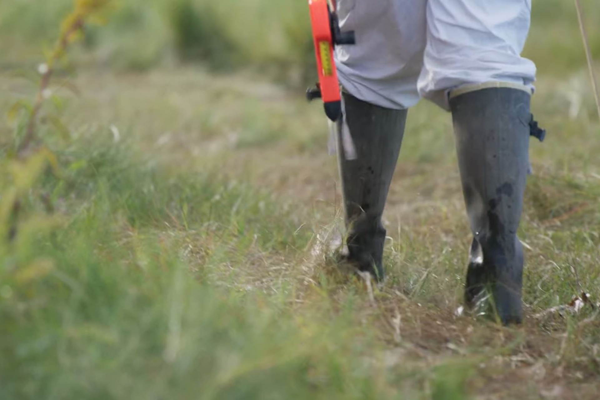 close up of person walking in high rubber boots