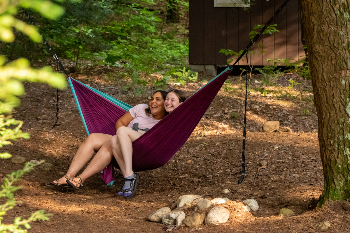 Counselor and camper sitting in hammock