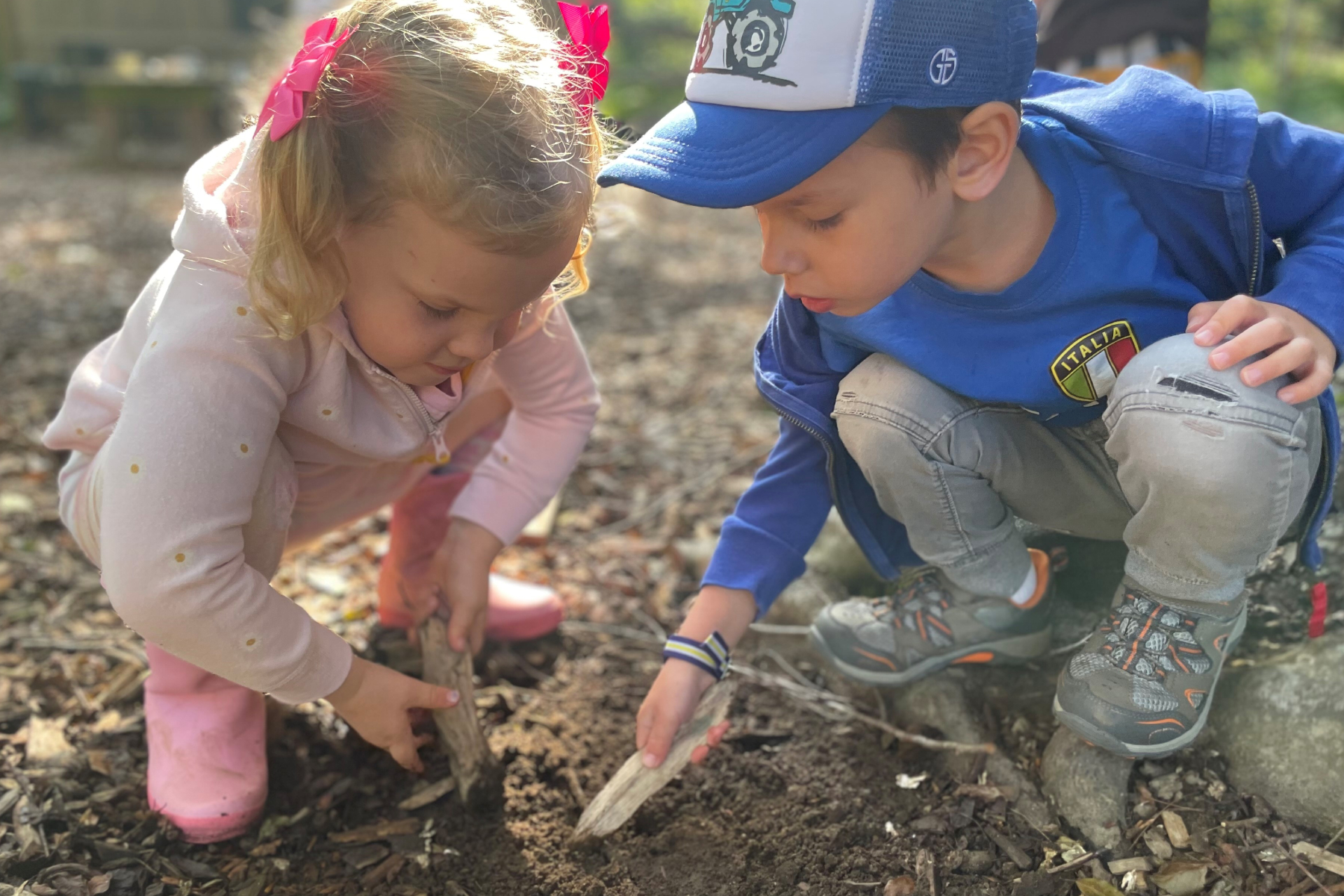 Two children dig in the dirt.