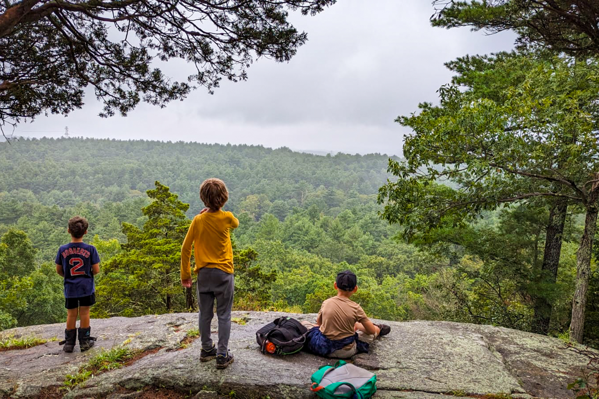 Three campers enjoy the view from the Bluff Overlook at Moose Hill Wildlife Sanctuary