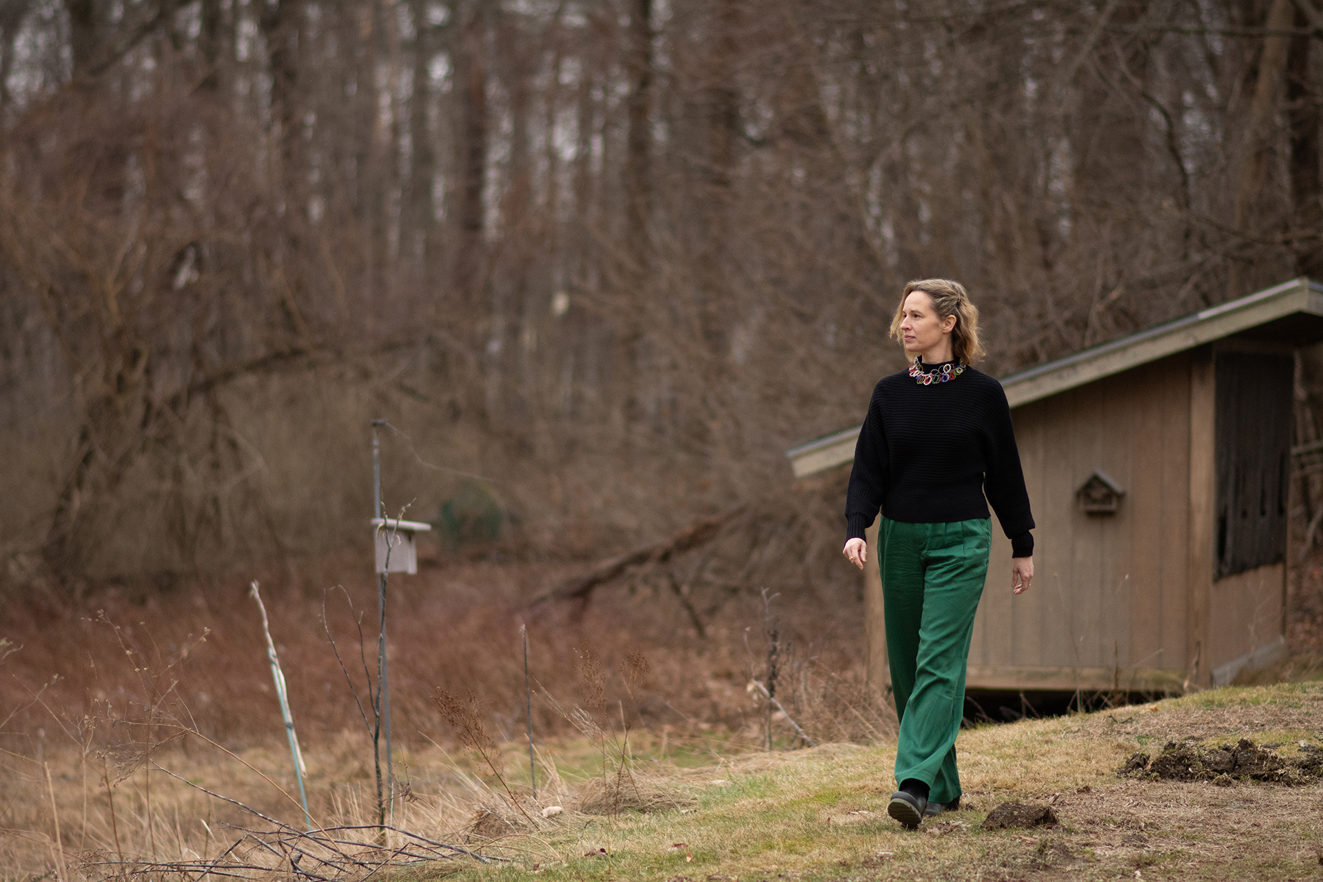 Jennifer walking with green pants and black sweater