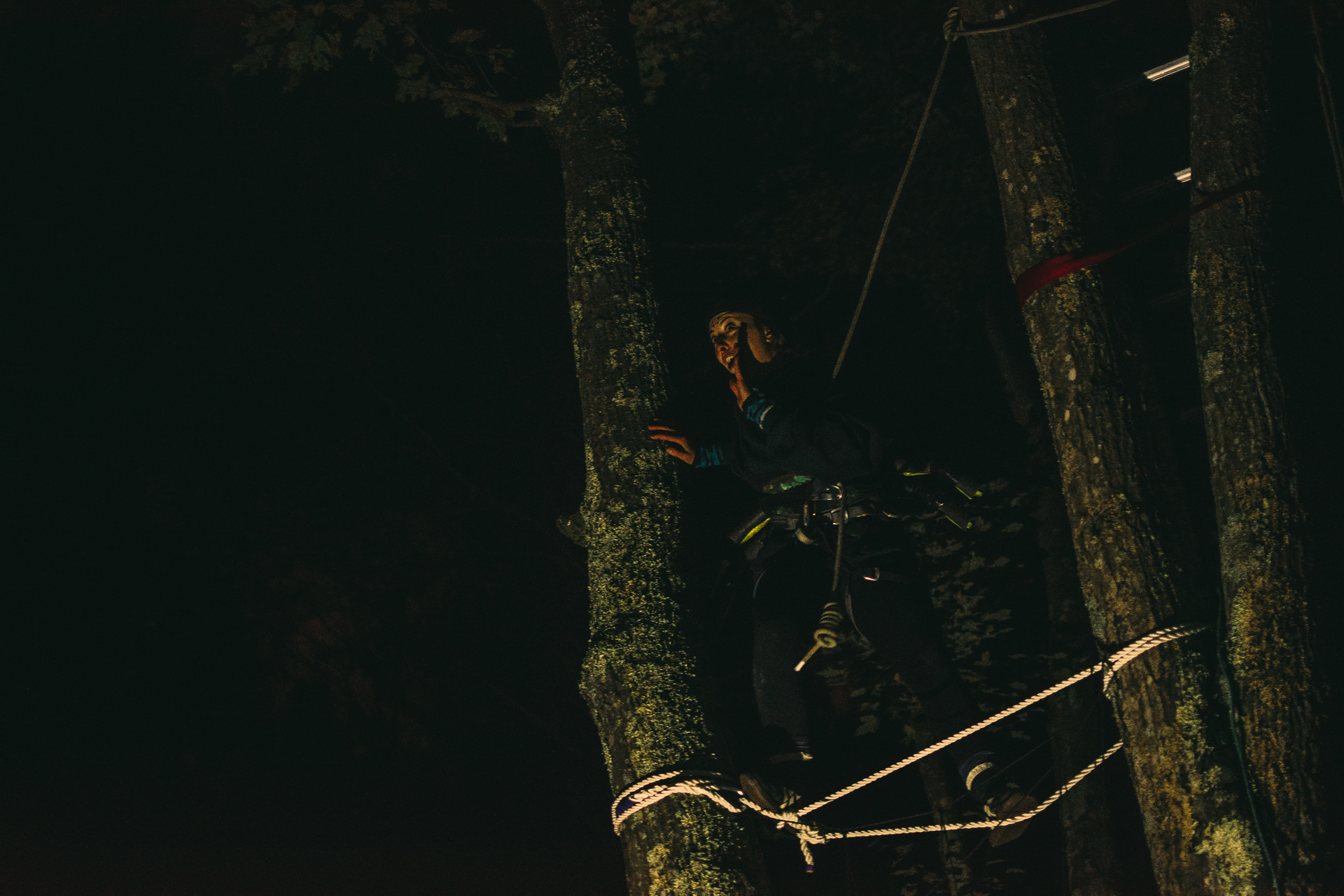 Costumed actor on a ropes course at night
