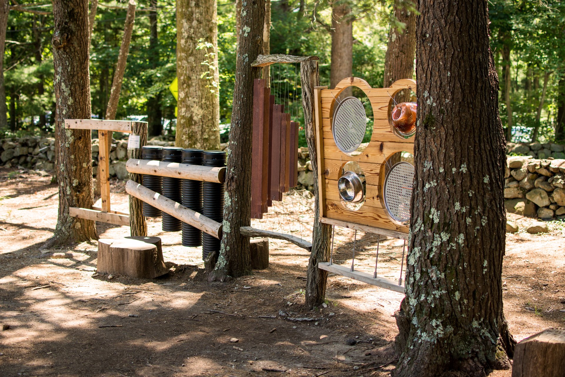 Nature play area for children with wooden puzzles and climbing materials.