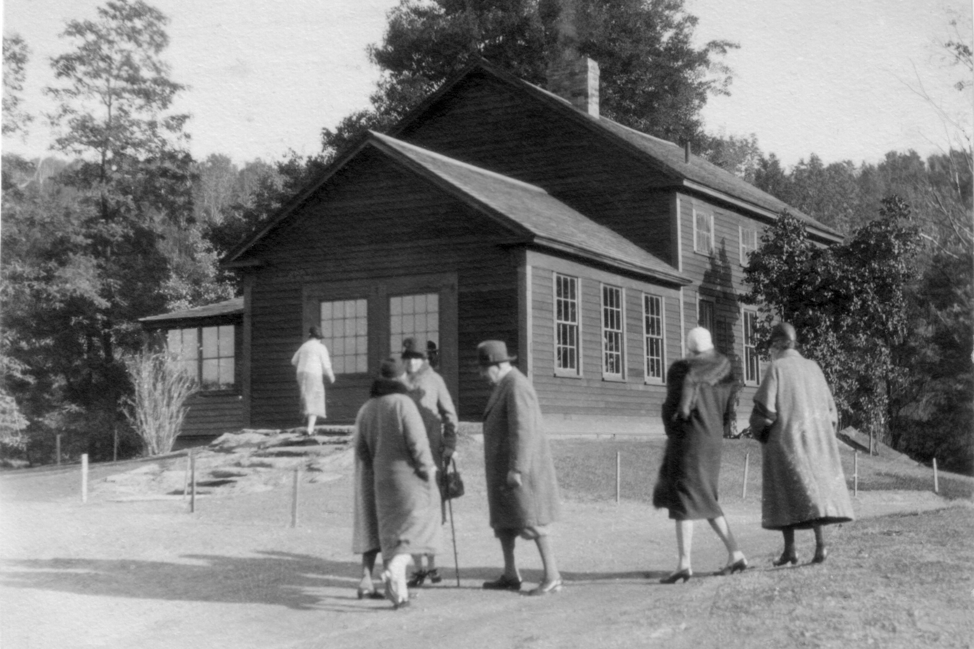 Historic black and white photo of ladies walking to a building at Pleasant Valley
