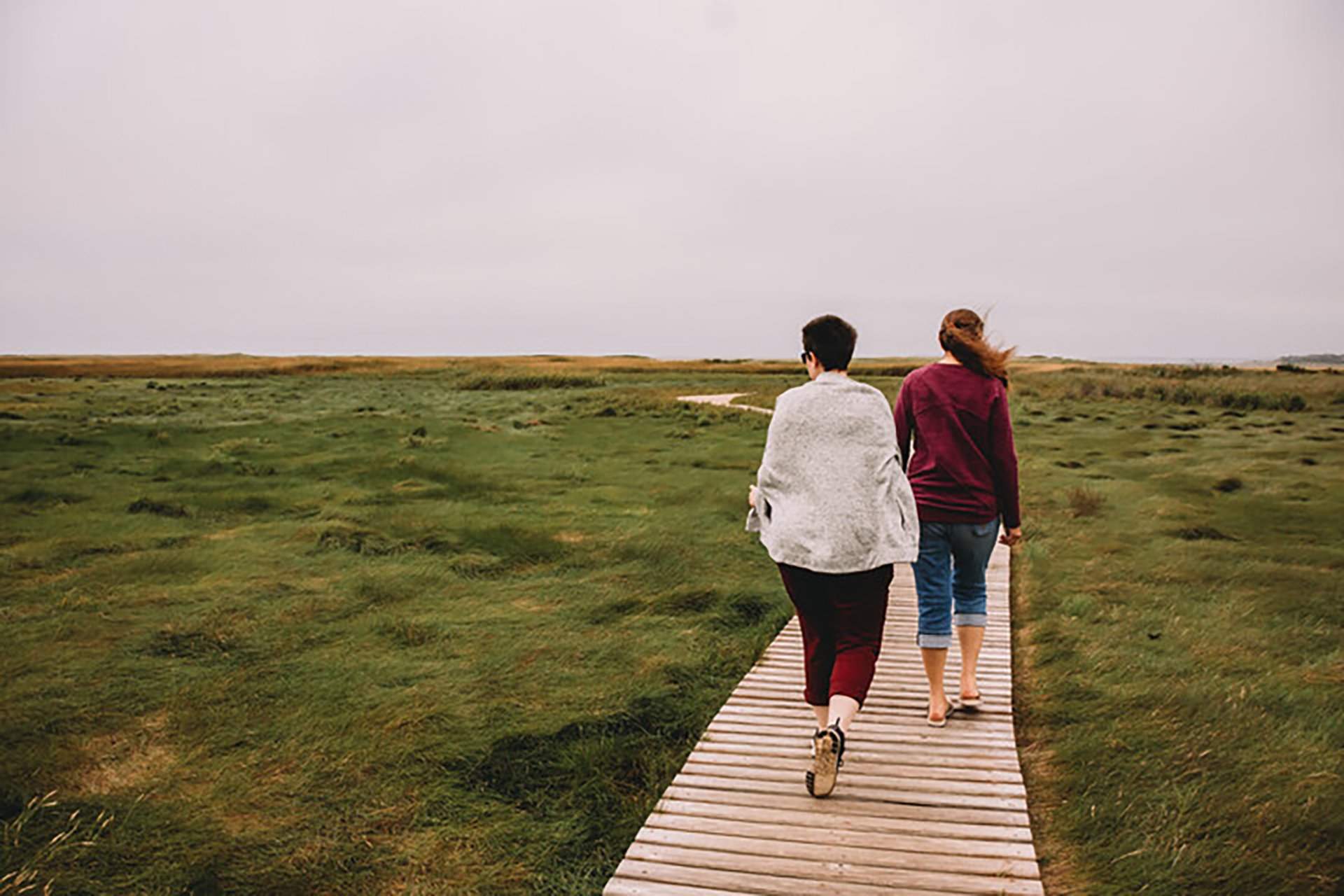 Two people walking on a boardwalk