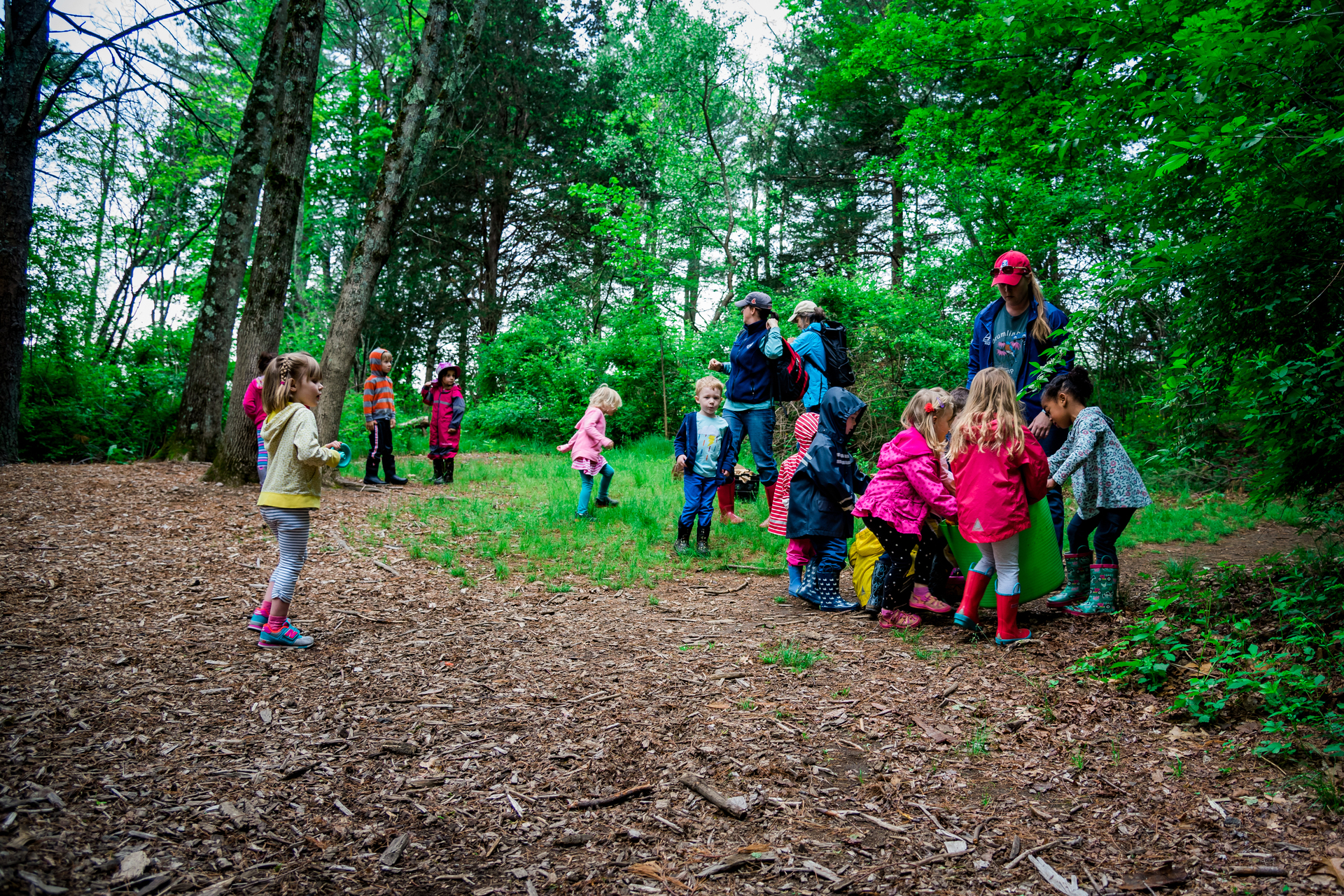 group of preschools wearing rain jackets in the field