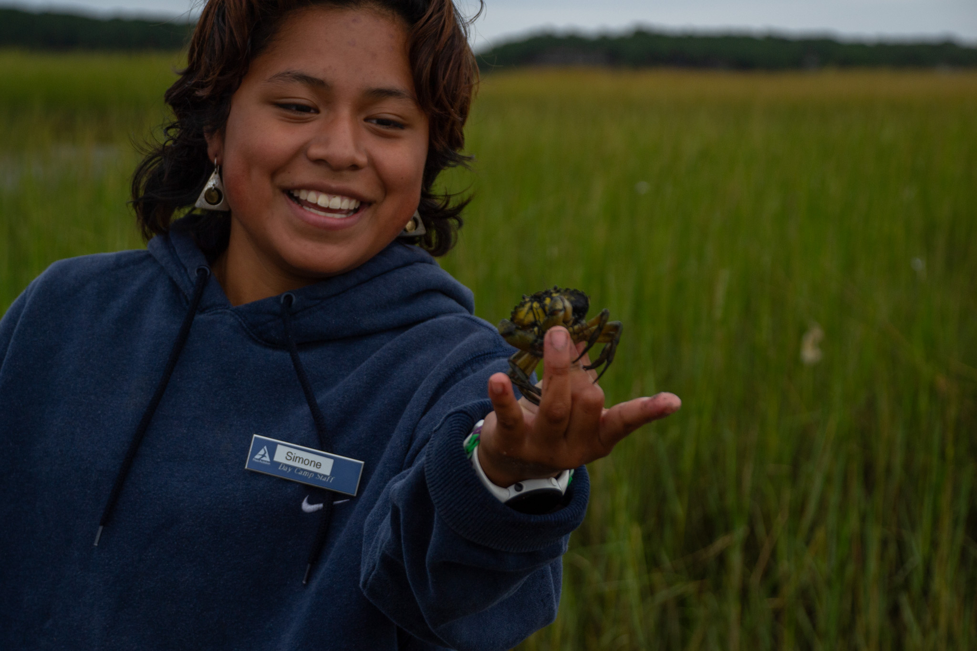 A counselor holds up a crab.
