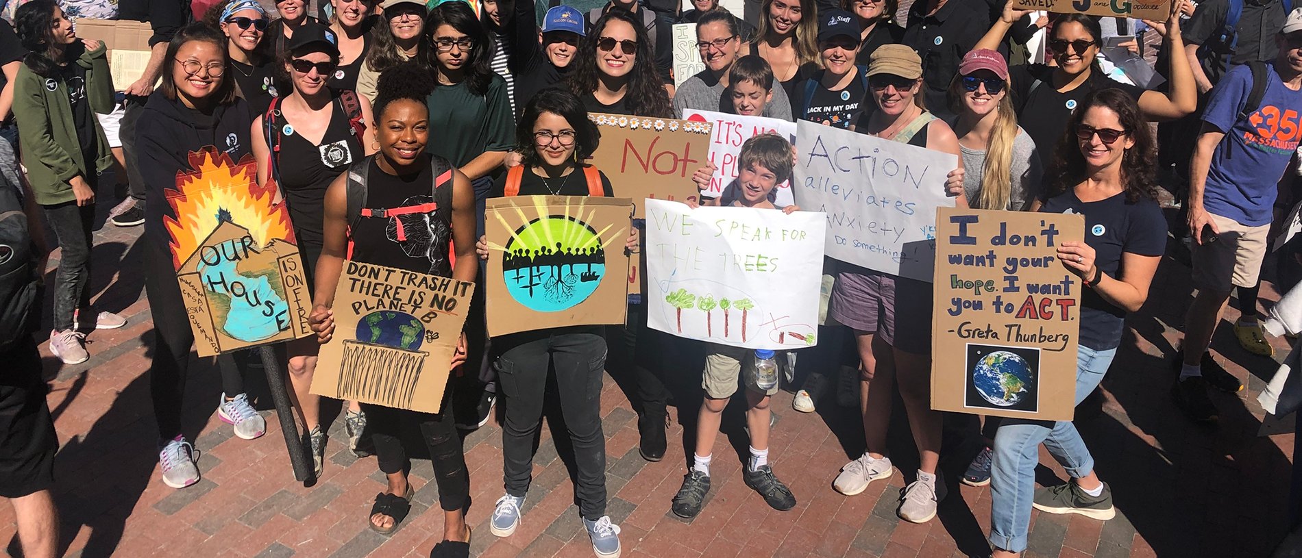 Young adults standing with signs demanding action on climate change