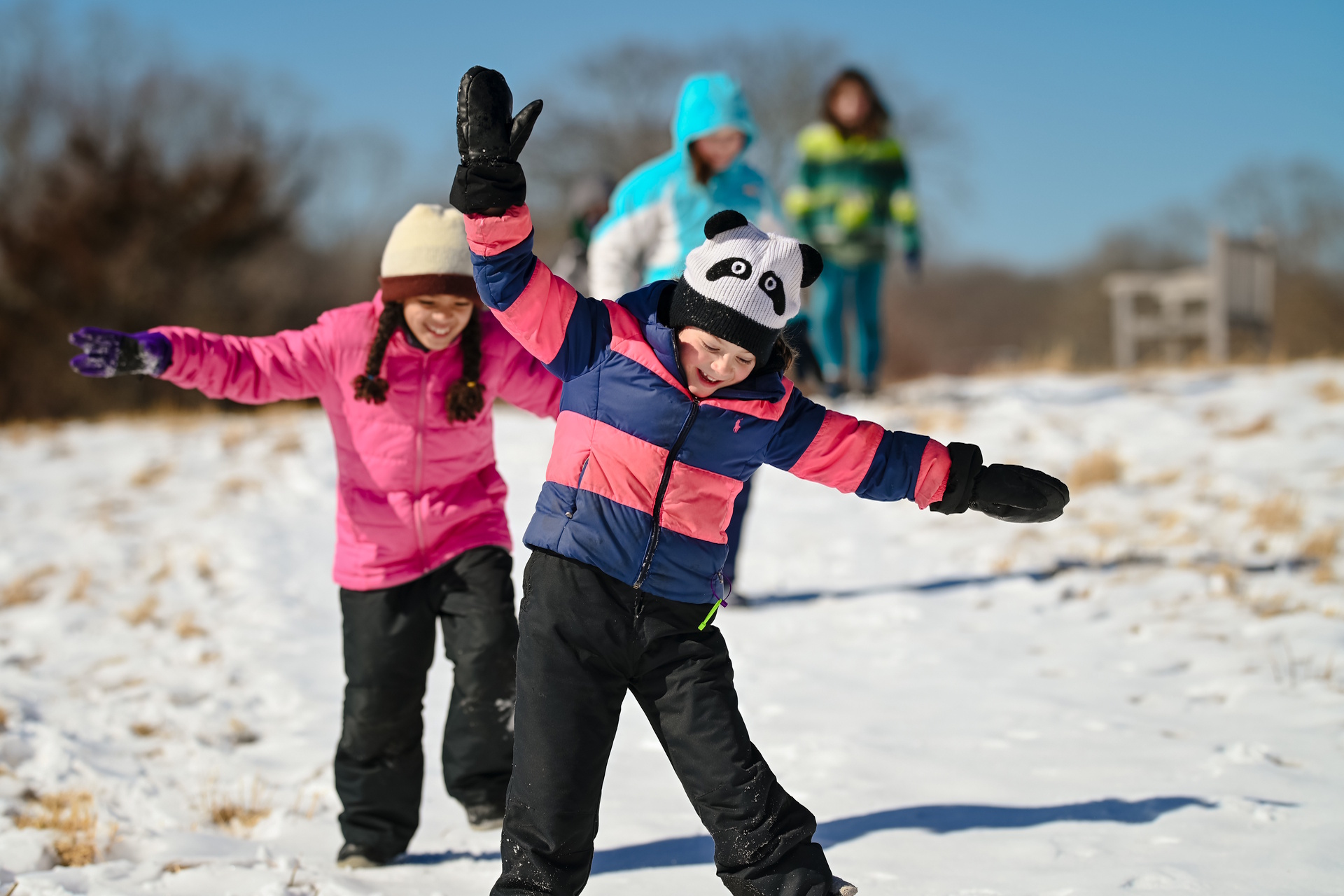 Two children walking along a snowy trail