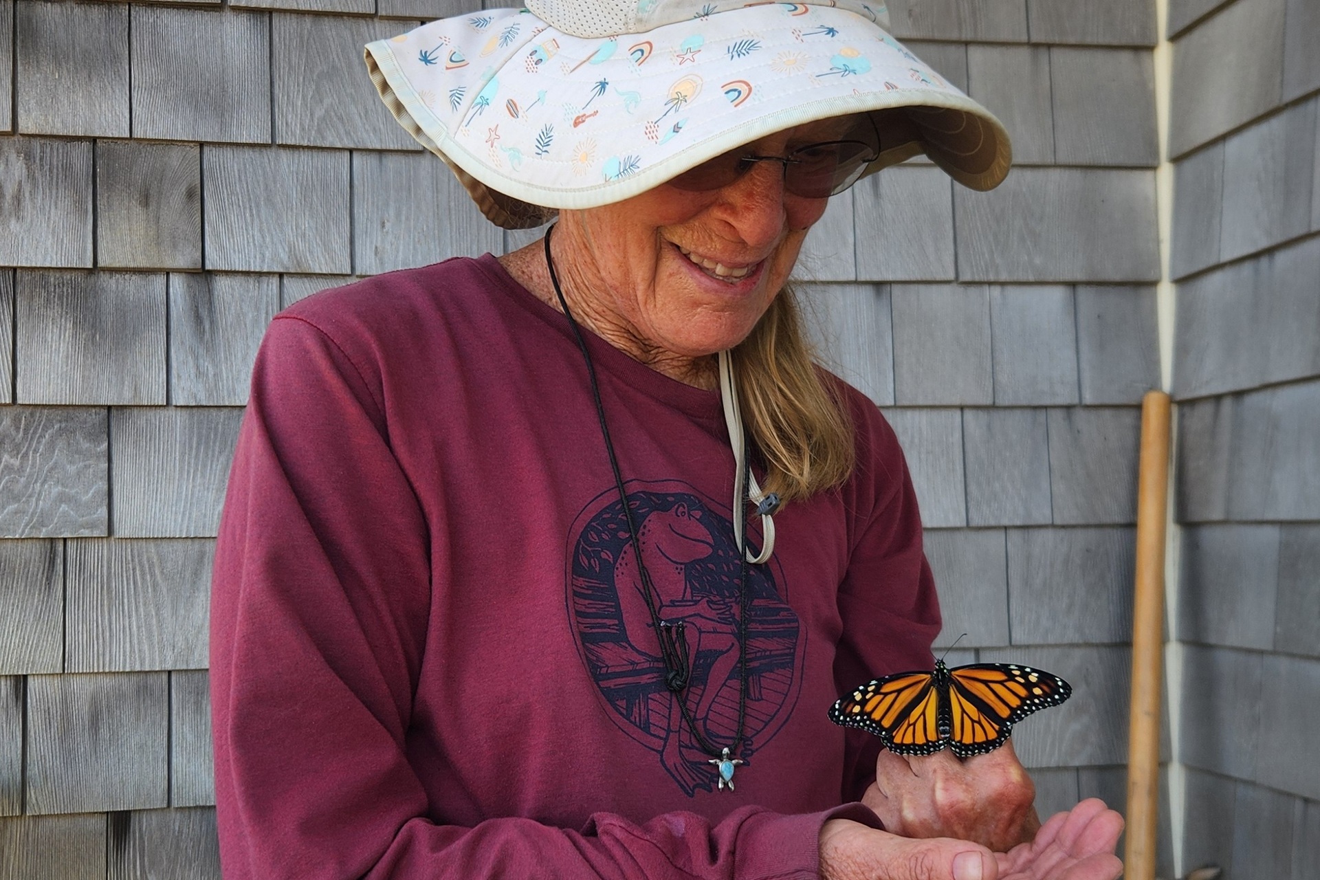 Wellfleet Bay volunteer Nancy Braun holding a Monarch butterfly