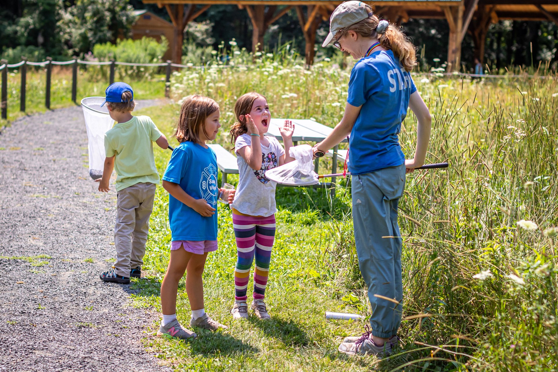 Campers at Arcadia Nature Camp exclaiming with delight at a specimen in a bug net held by a counselor
