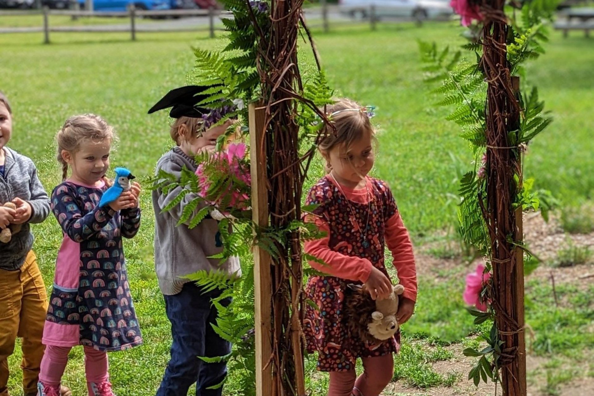 preschools walking through an arch on graduation