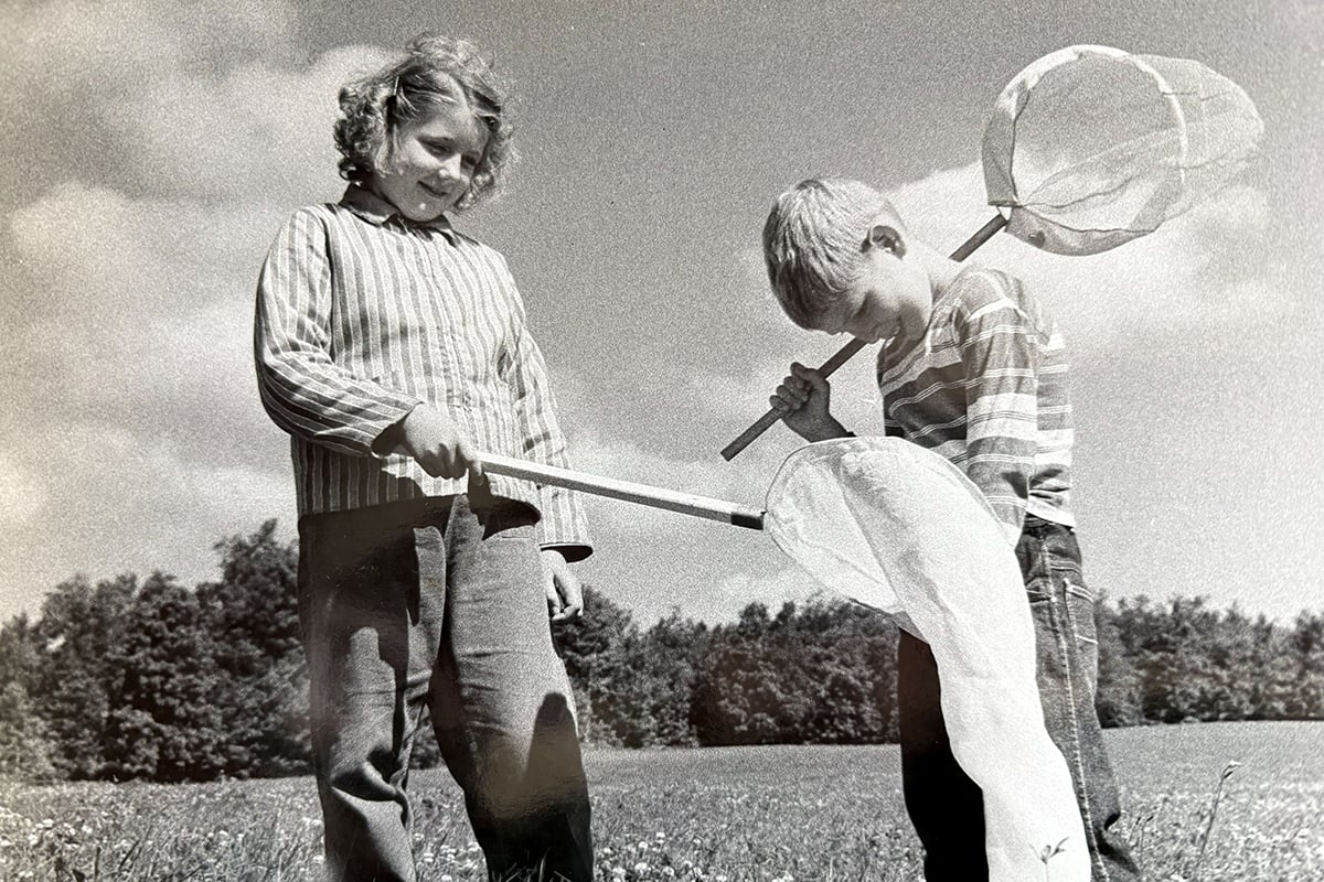 Black and white historic photo of children holding nets