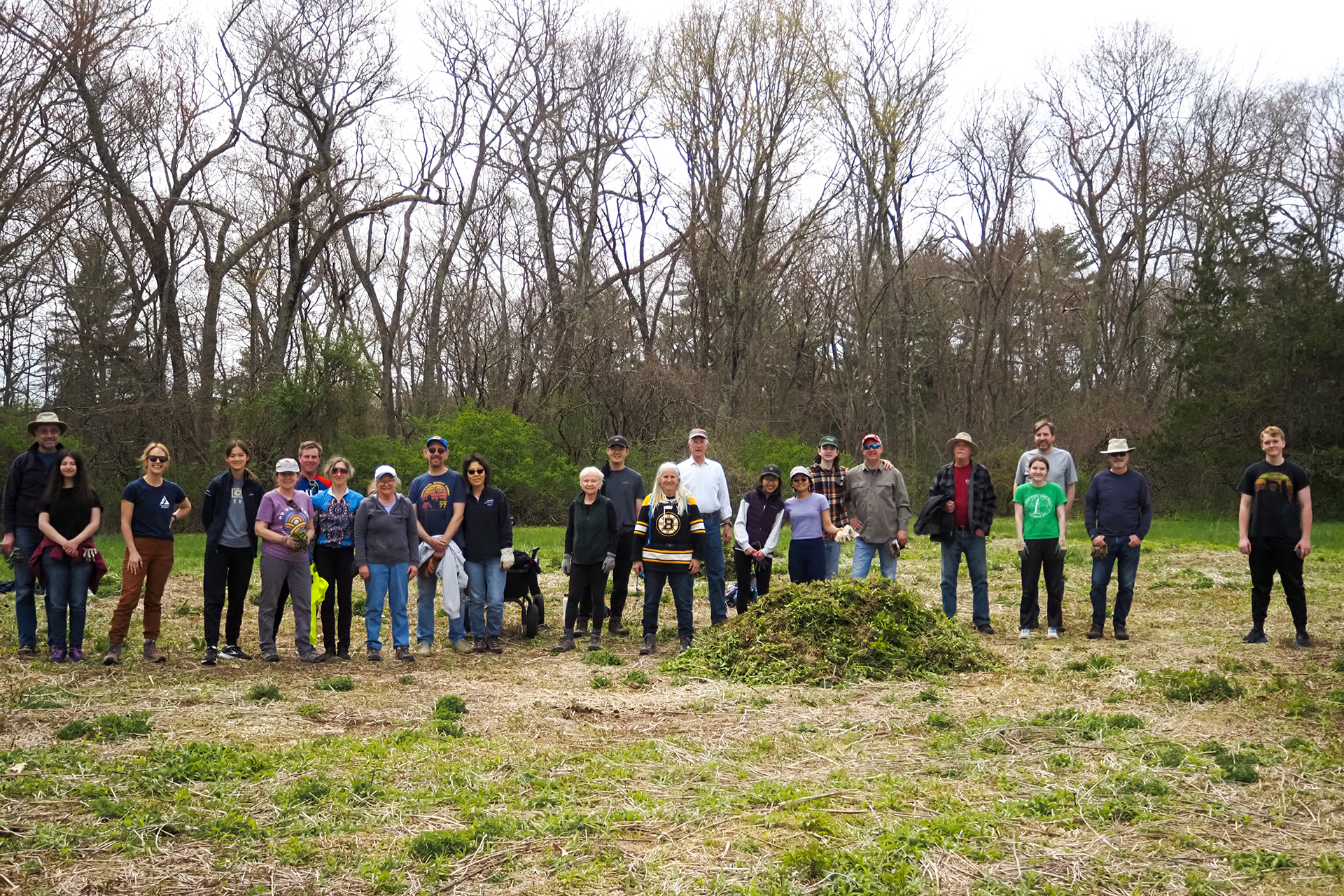 Large group of volunteers posing for a photo in a cleared field
