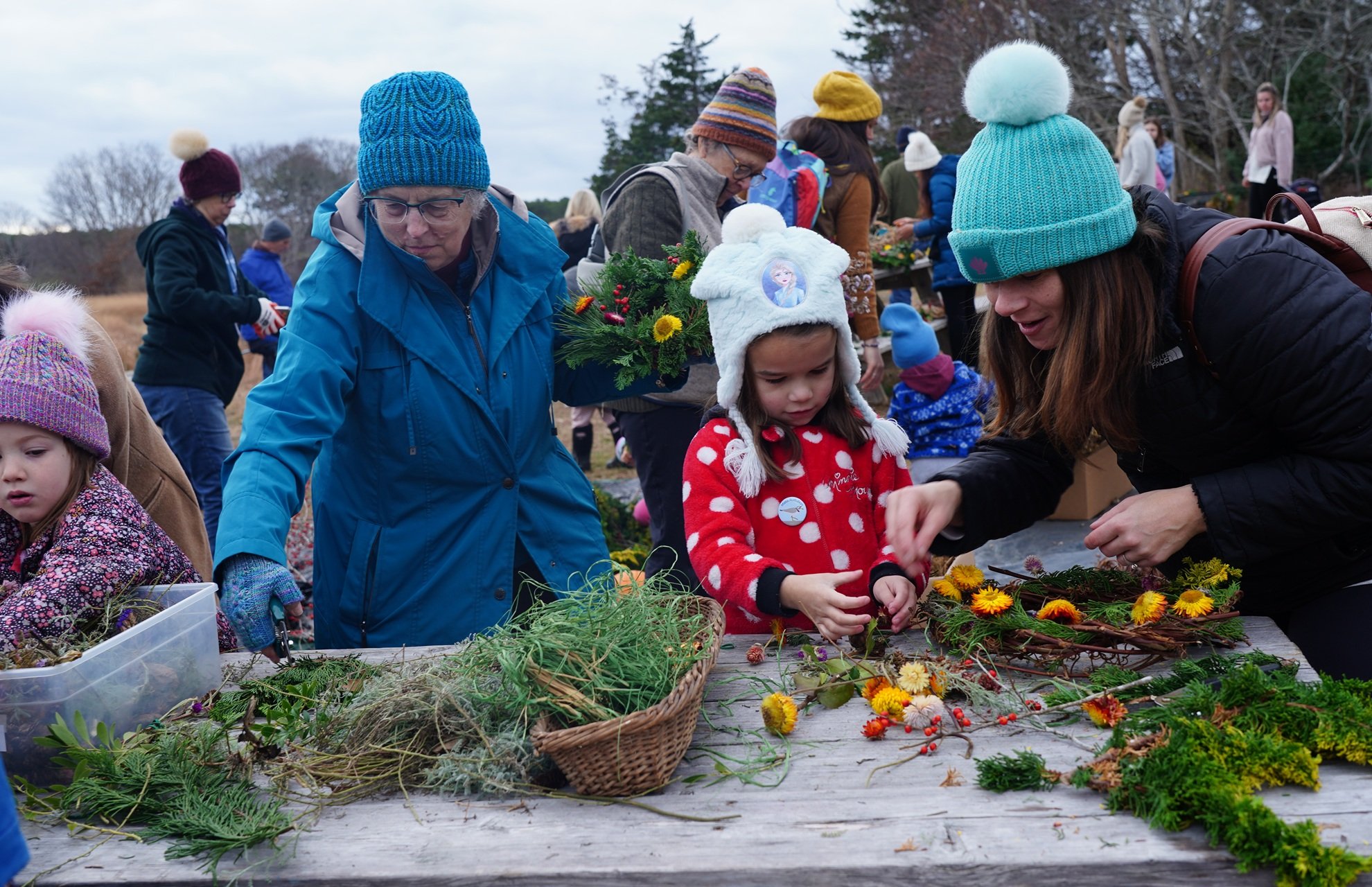 People gathered around a craft table working on nature craft