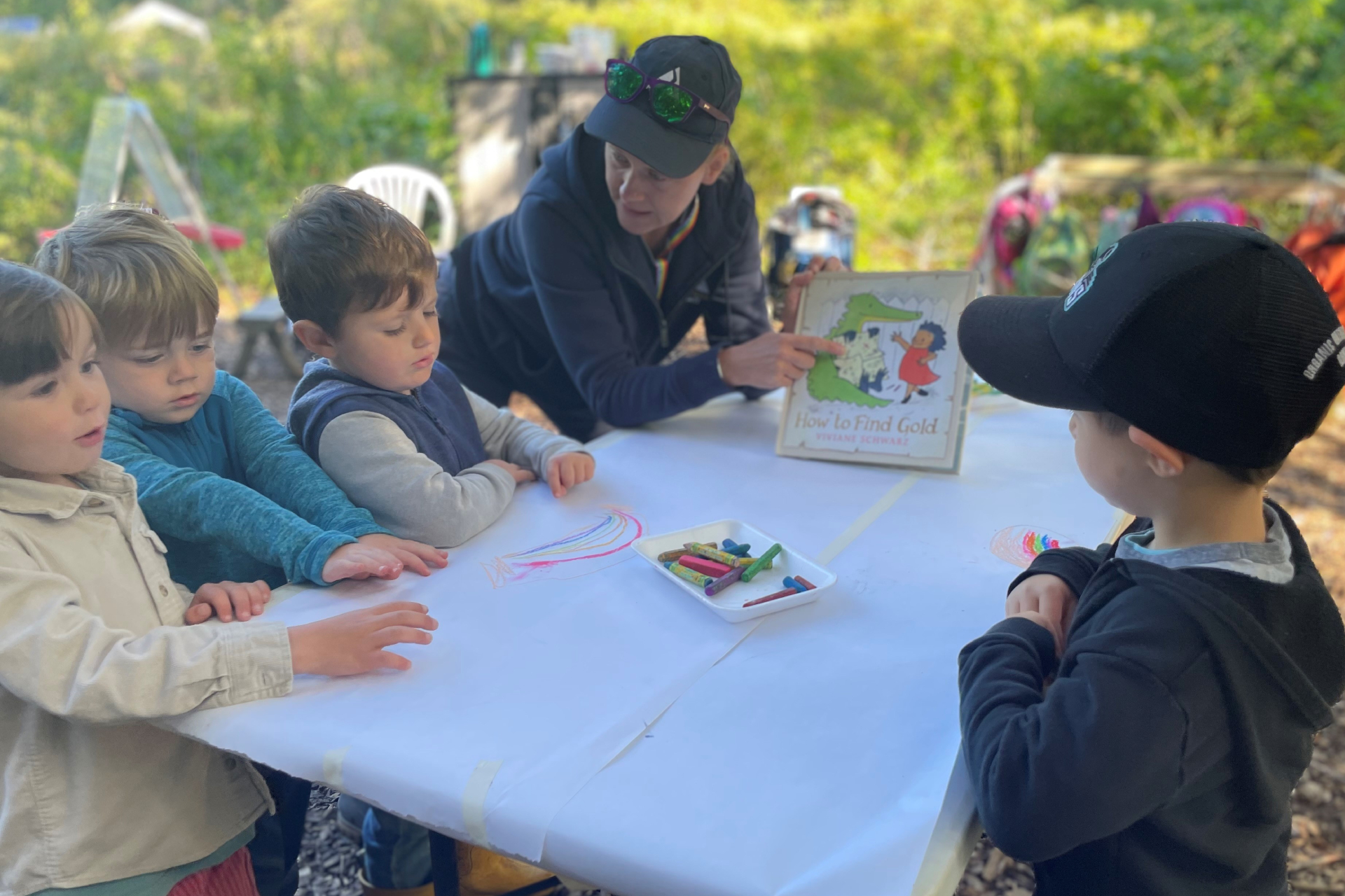 A teacher naturalist shares a picture book with a group of children.