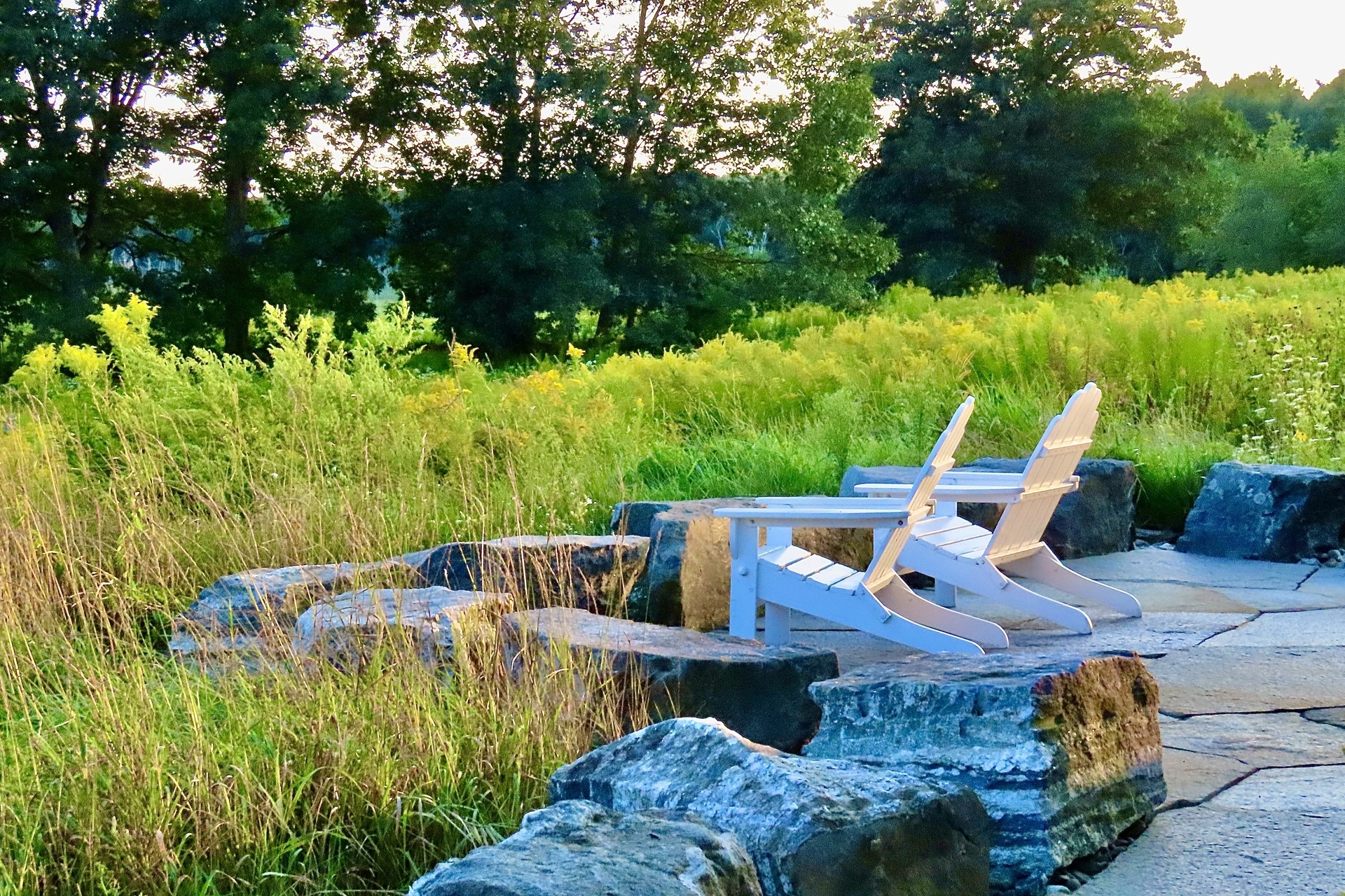 two Adirondack chairs on stone patio