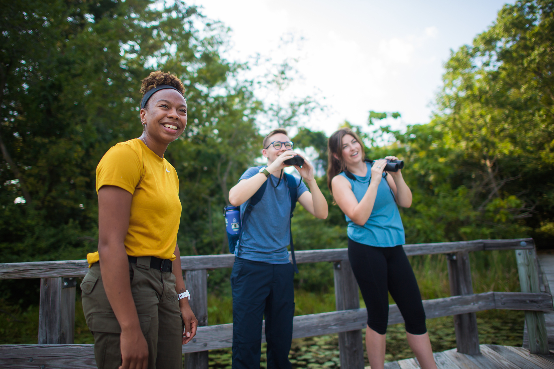 Three people looking into distance with binoculars