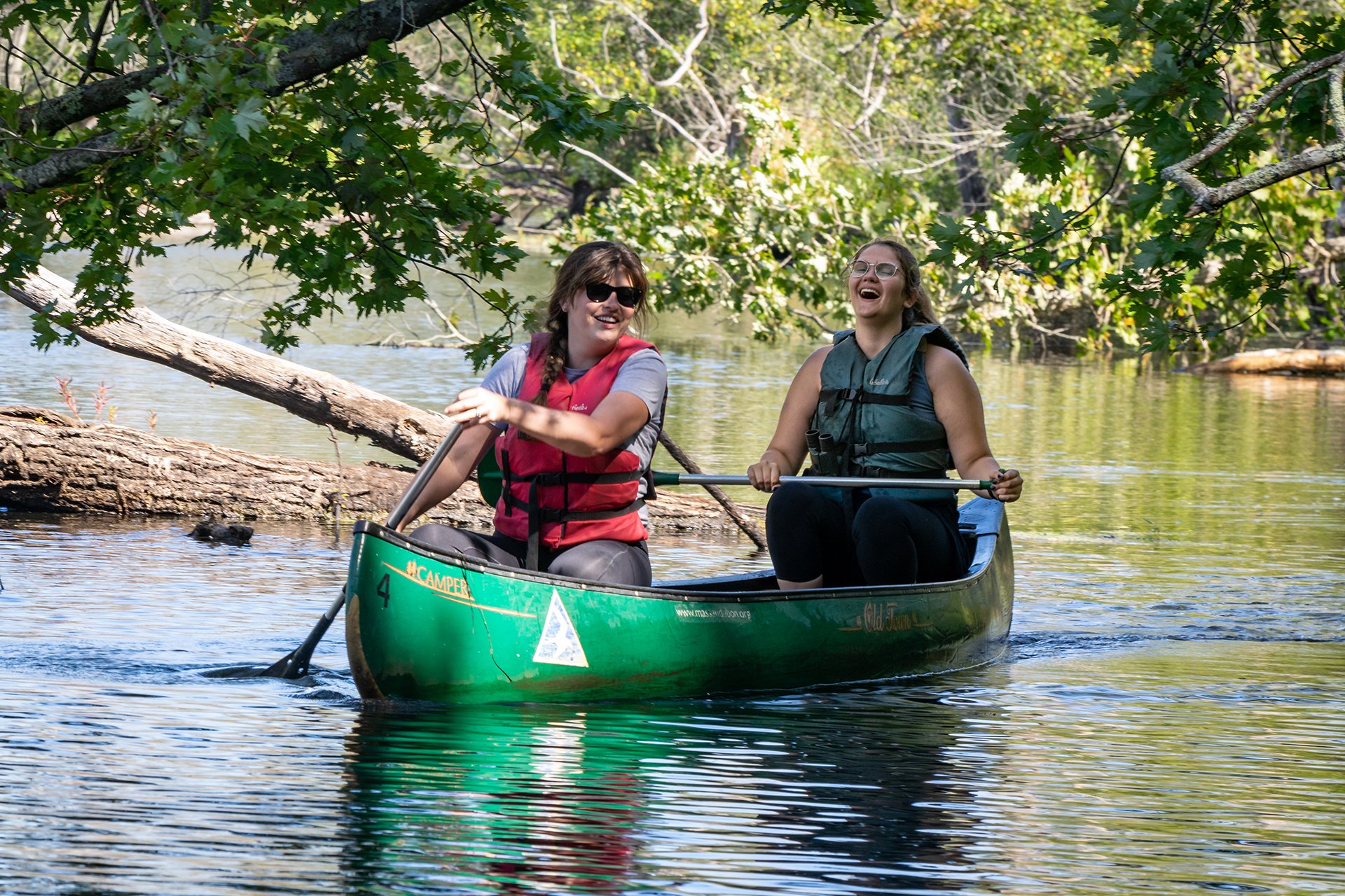 two people in a canoe paddling and laughing