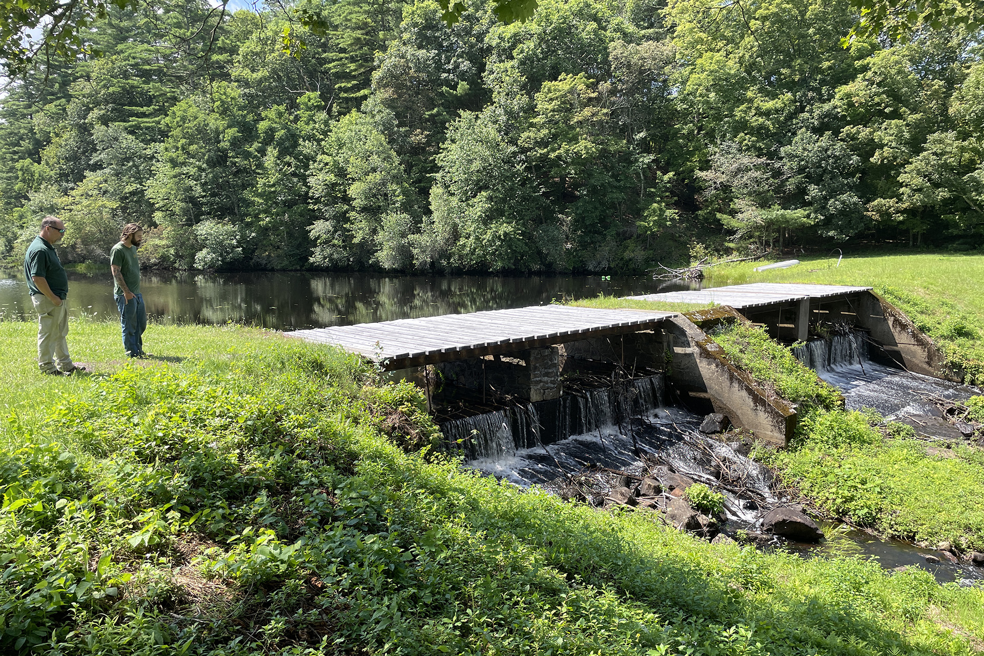 Two people looking at a bridge over a dam