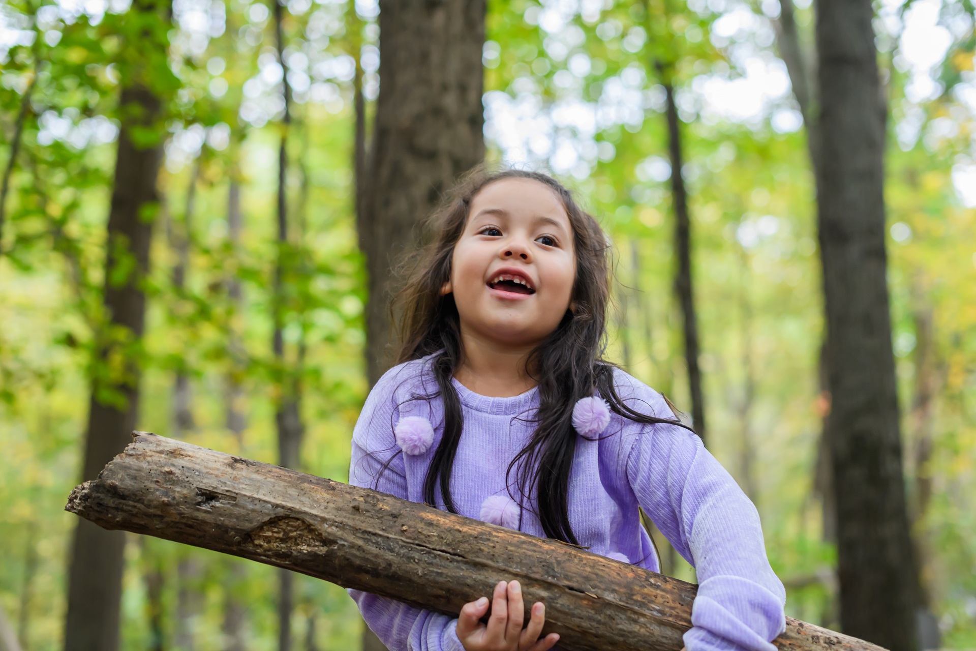 Young girl holding a small log