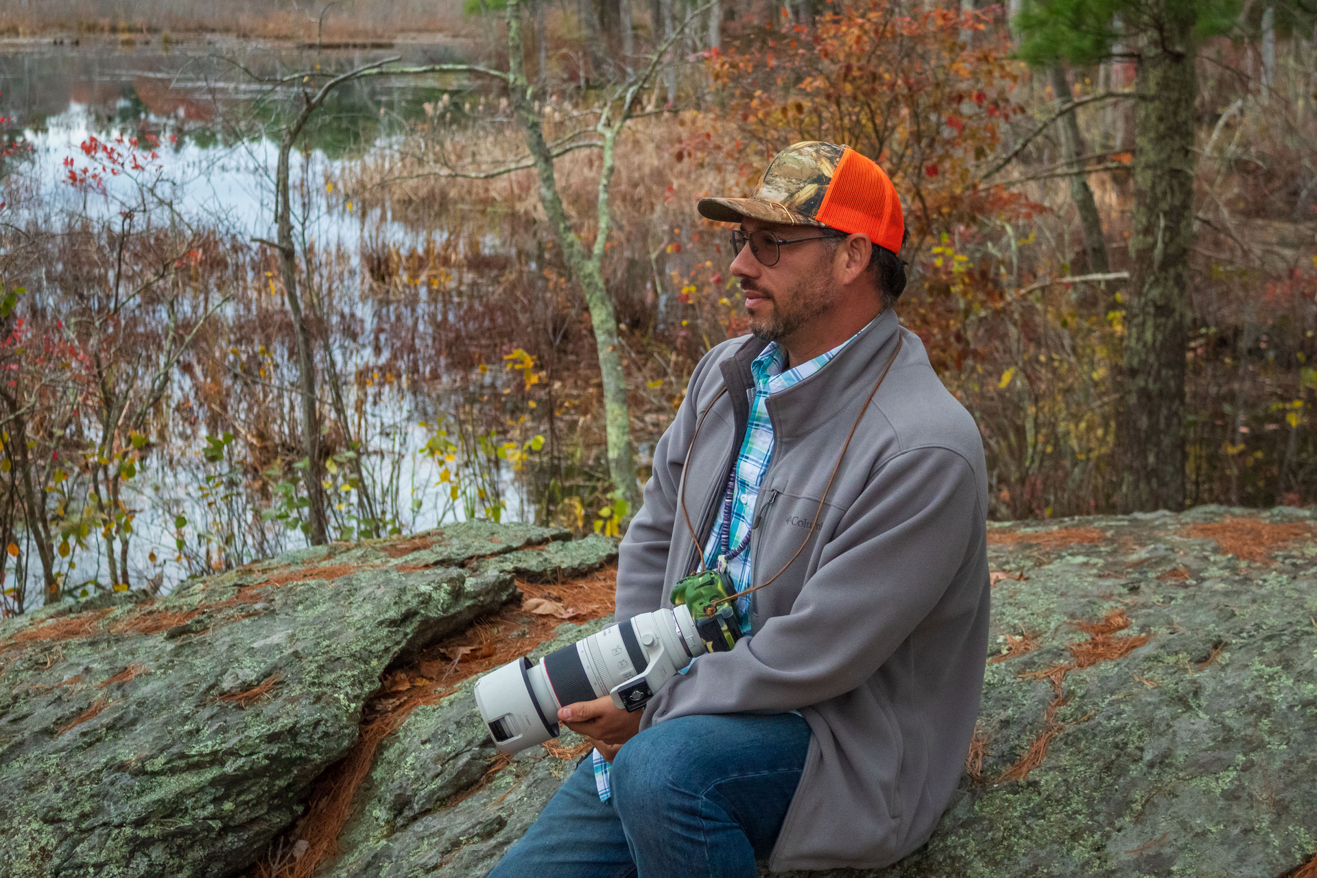 Waban Webquish sitting for a posed portrait with a camera and telephoto lens