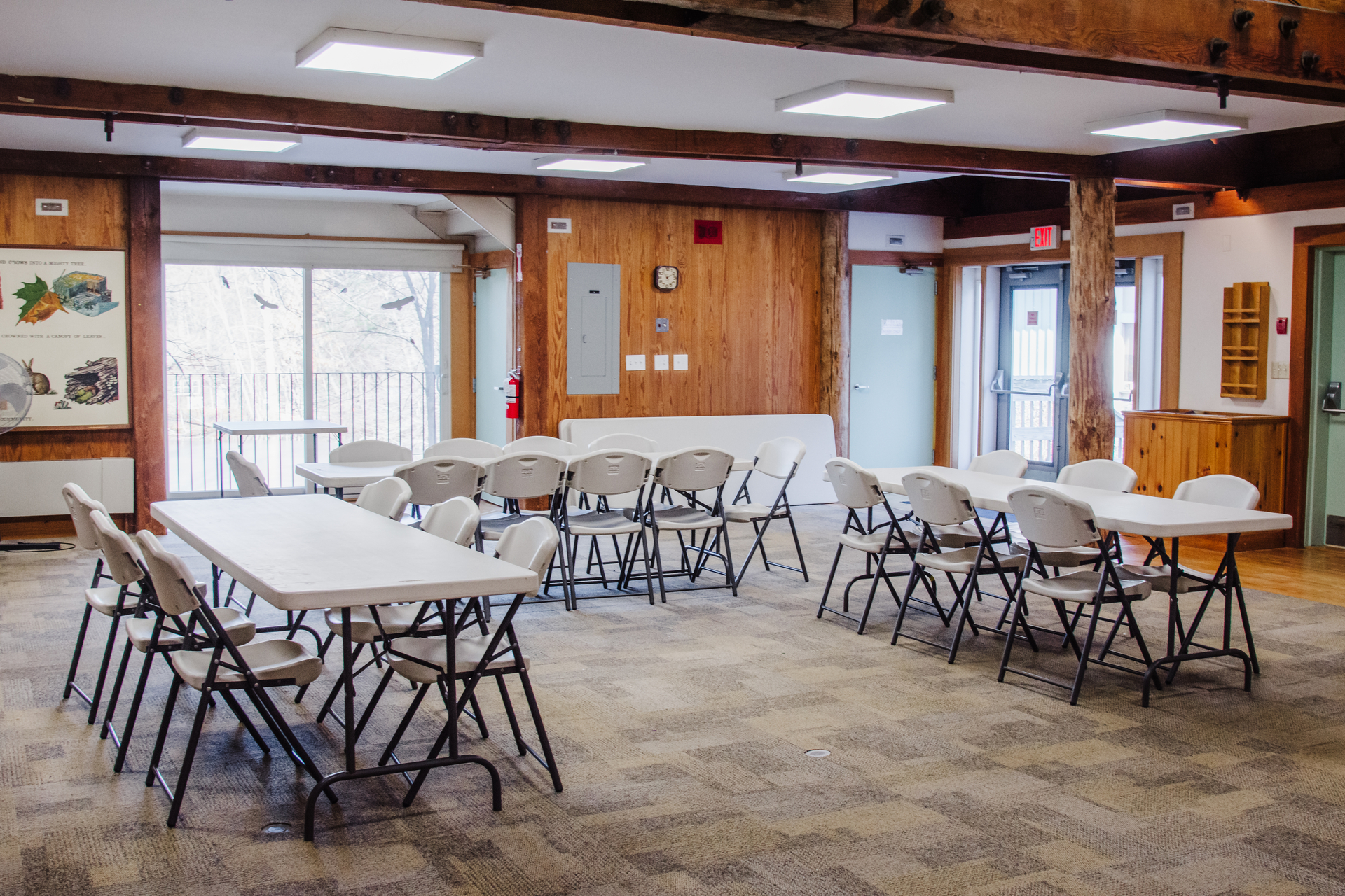 Blue Hills Auditorium set up with three tables and multiple chairs - photo taken from an angle