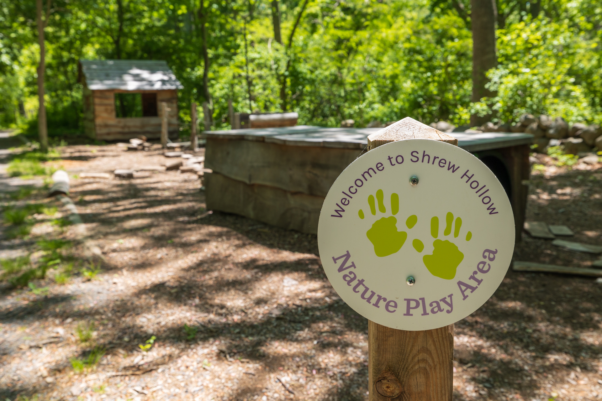 Sign reading "Welcome to Shrew Hollow" in front of North River's nature play area