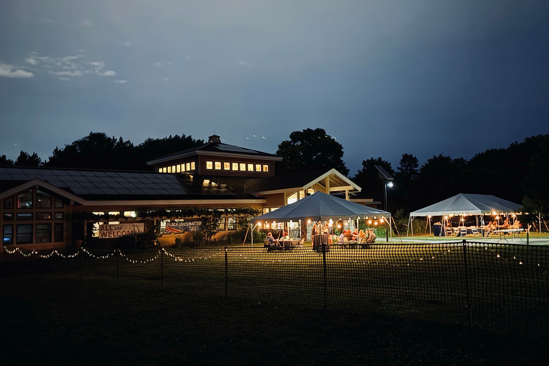 BNC Tents and buildings lit up on a summer evening