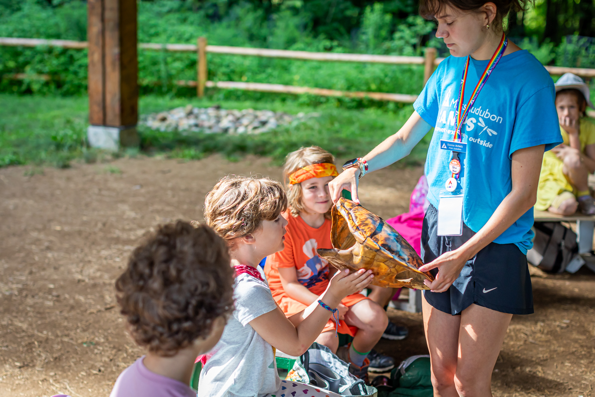 A counselor at Arcadia Nature Camp holds out a large turtle shell for campers to touch and inspect