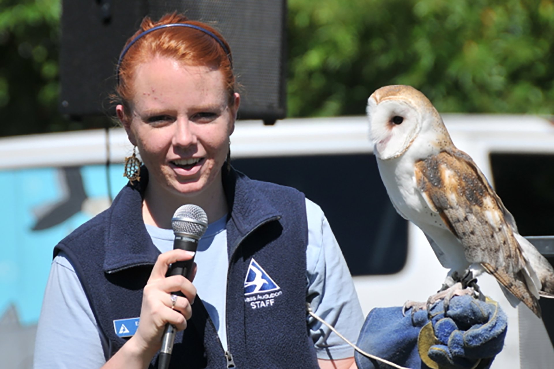 Educator holding an owl, perched on their hand