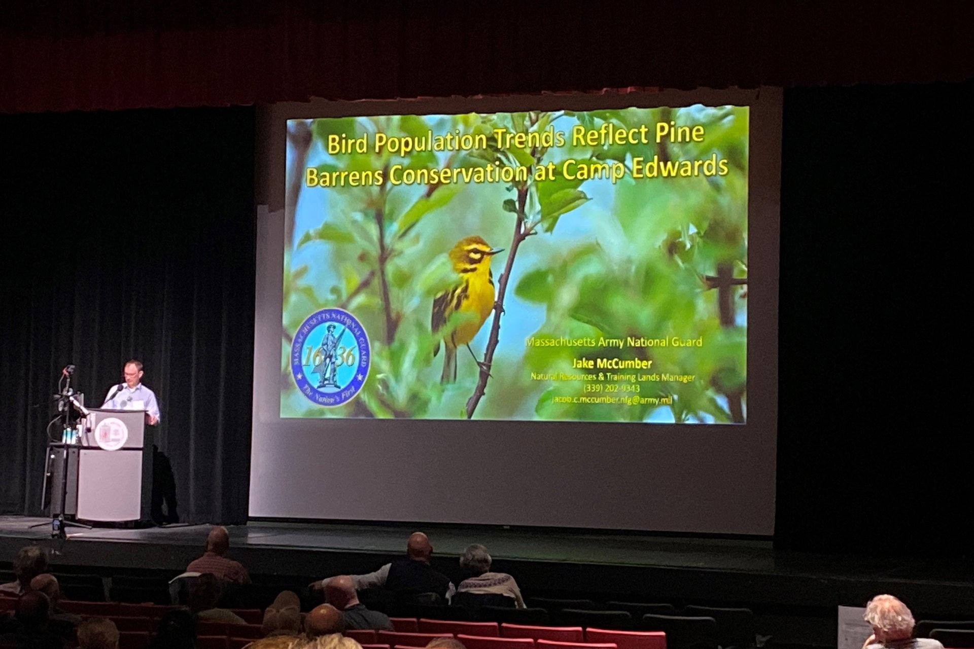 Cape Cod Natural History Conference presenter on stage at a podium