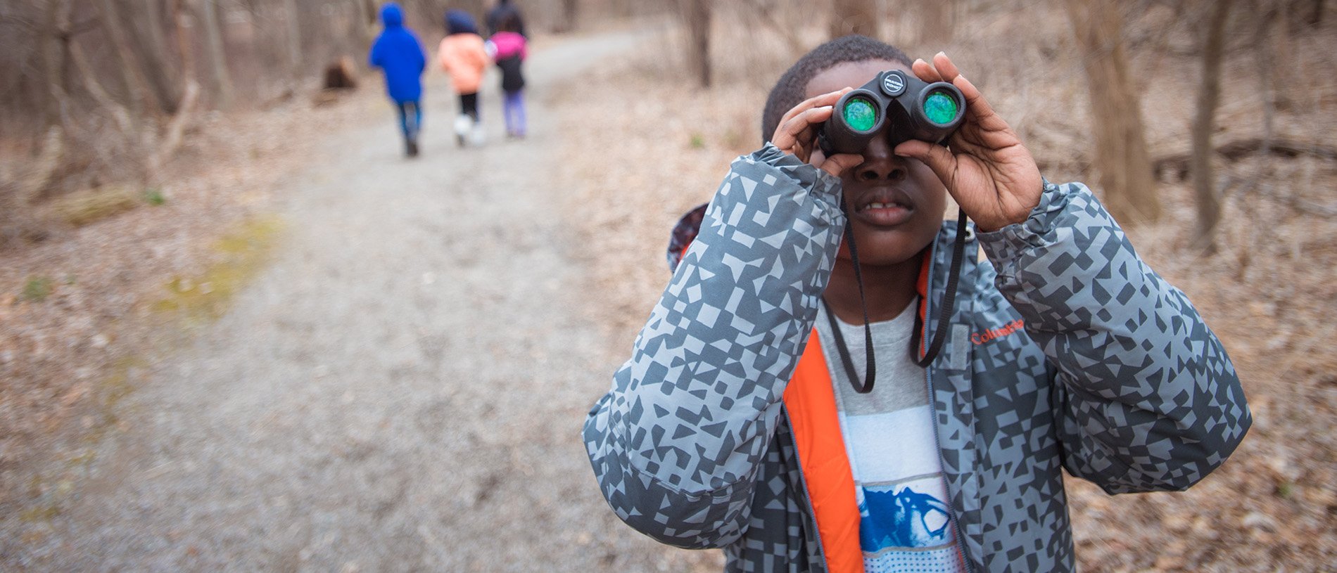 Boy looking through binoculars in winter