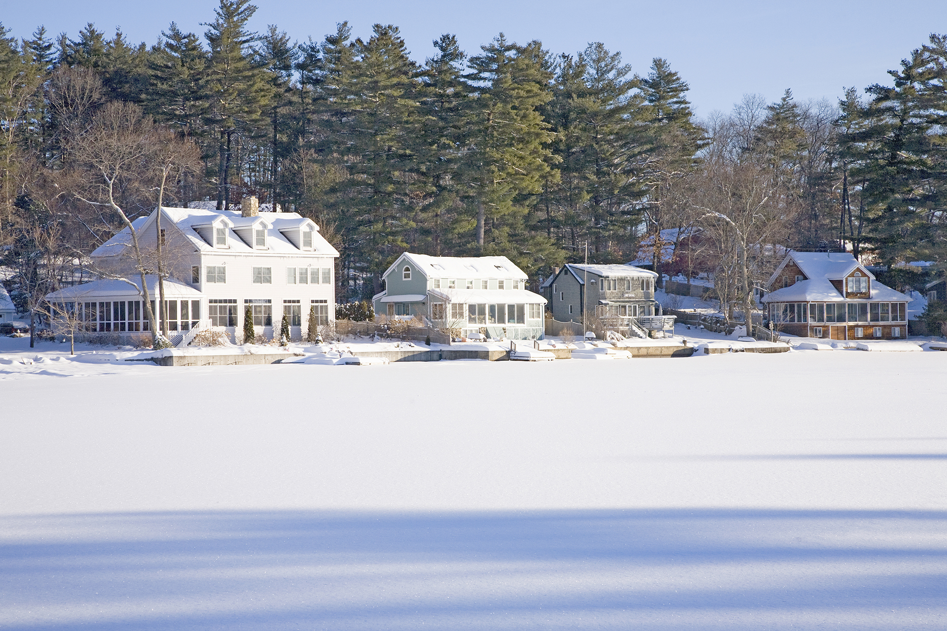 Buildings covered in snow behind a snowy field