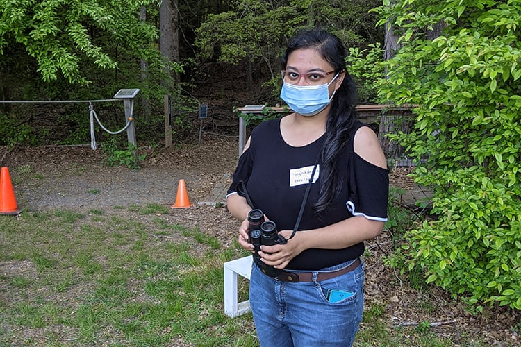 Birder with binoculars wearing mask