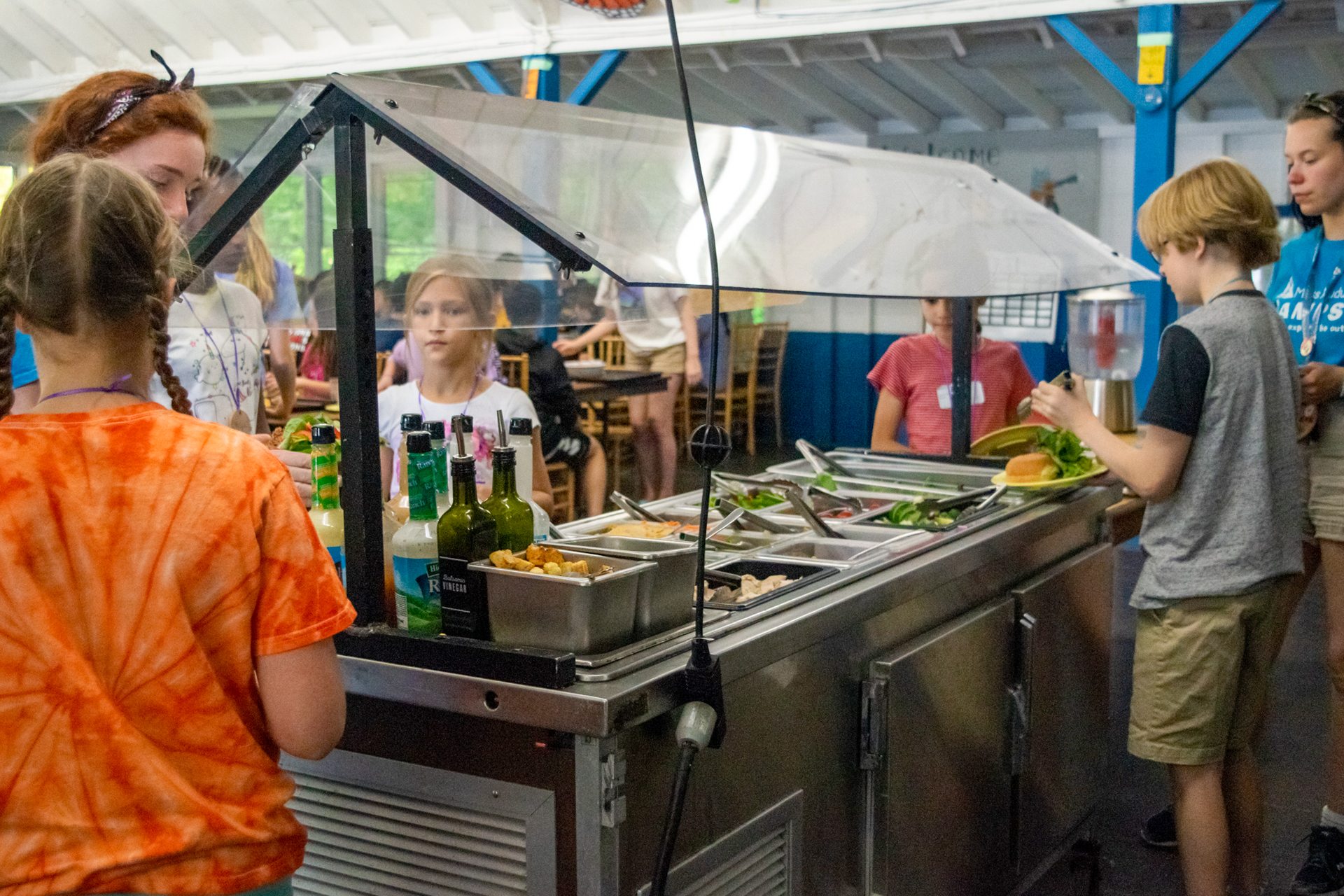 Campers and counselors load up their plates at the salad bar in Wildwood's dining hall
