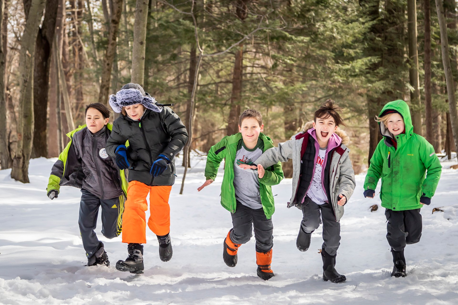 A group of children running on a snowy trail