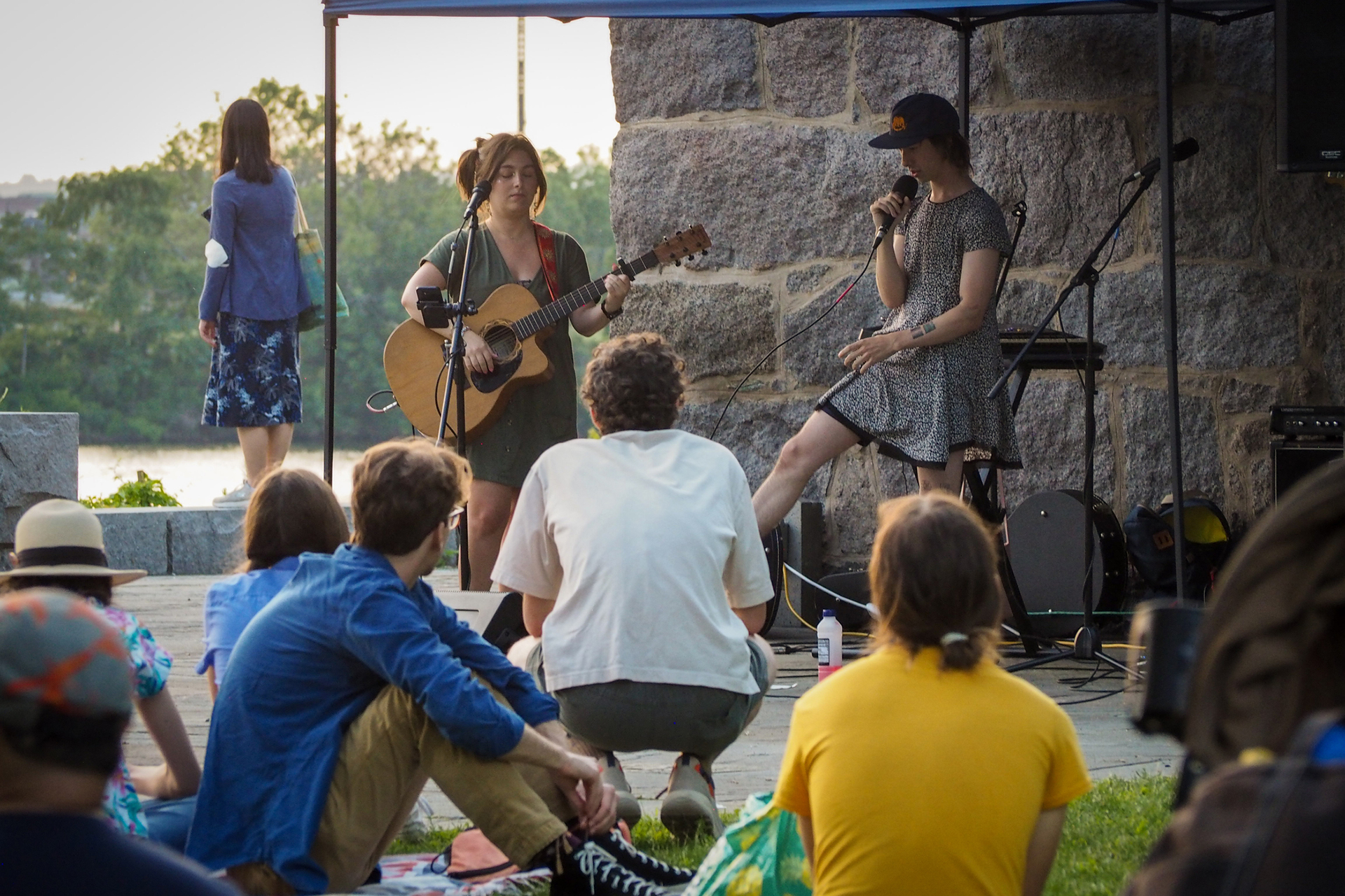 Musicians performing at a small stage outdoors