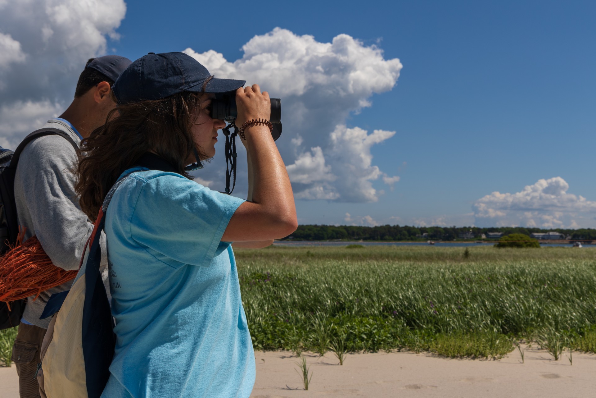 looking through binoculars on beach