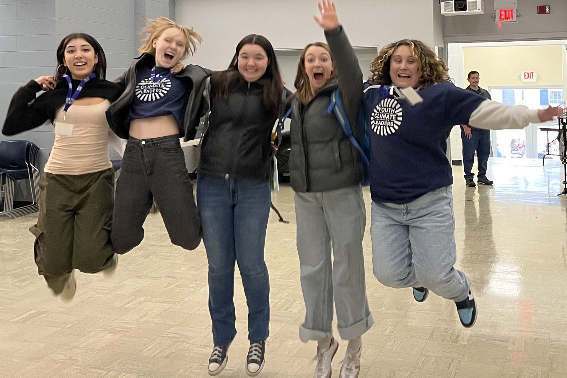 Group of five high-school-aged girls jumping in celebration